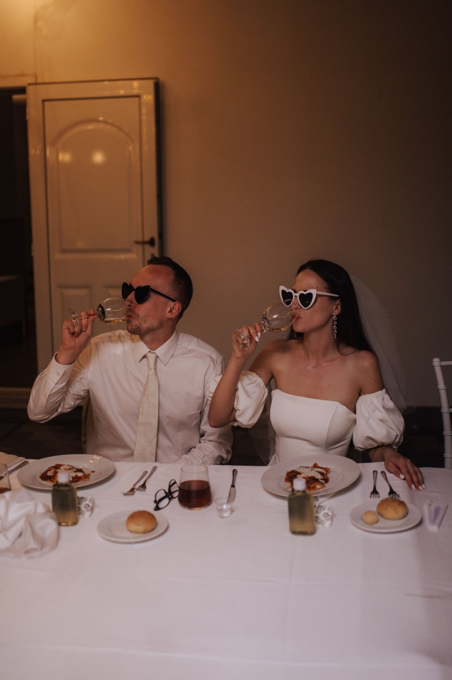 Zdjęcie pary młodej z gośćmi przy stole – swobodna i elegancka kolacja ślubna we Włoszech