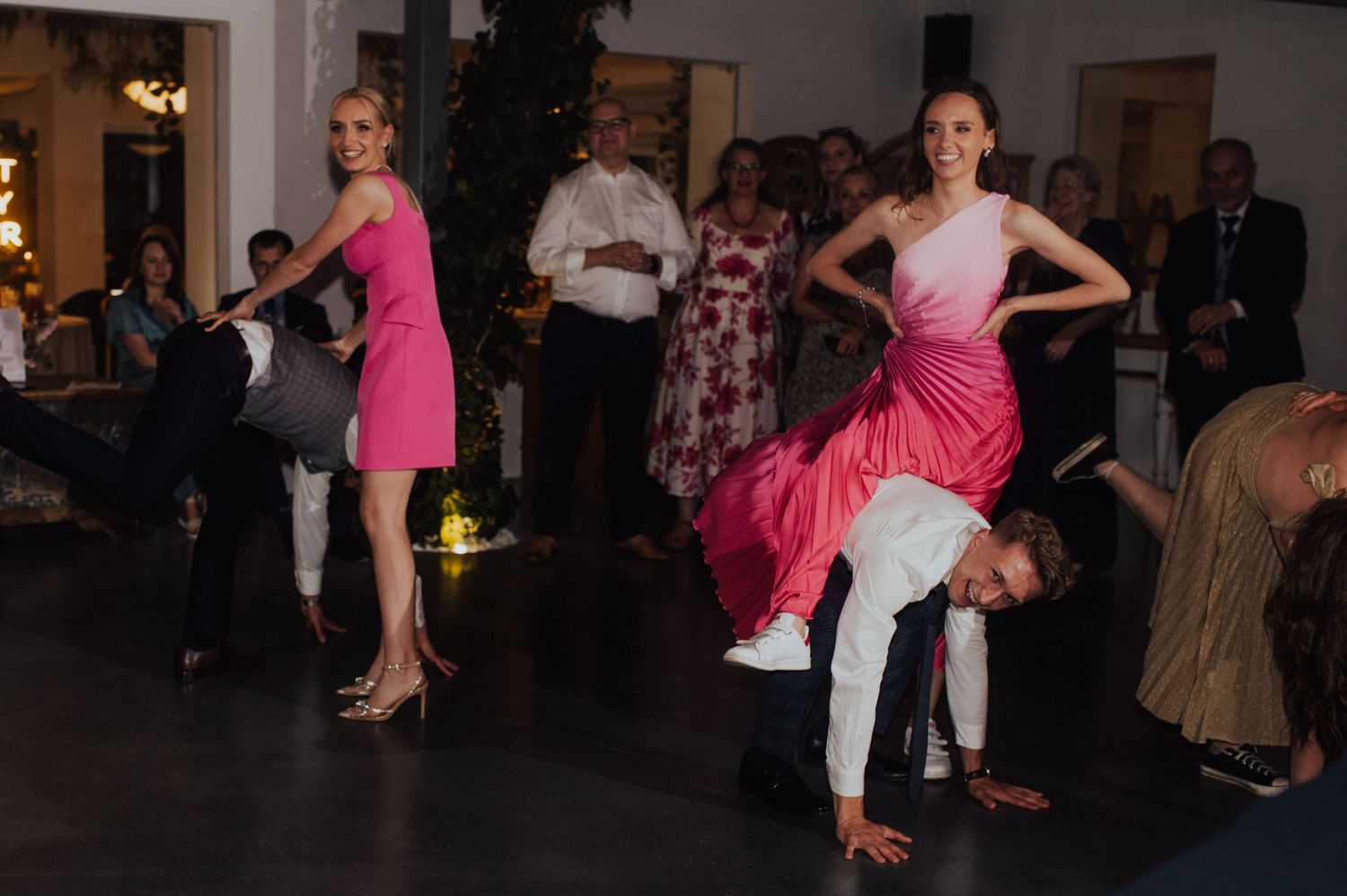 Goście weselni w zabawnej konkurencji – dynamiczna i luźna atmosfera eleganckiego wesela w Dębowcu.