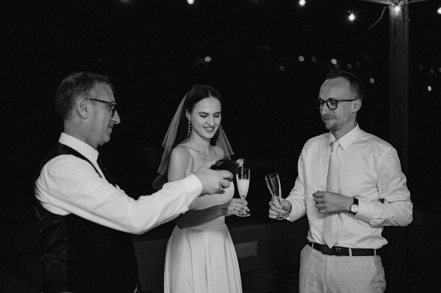 Symboliczny toast pary młodej szampanem w eleganckim otoczeniu.