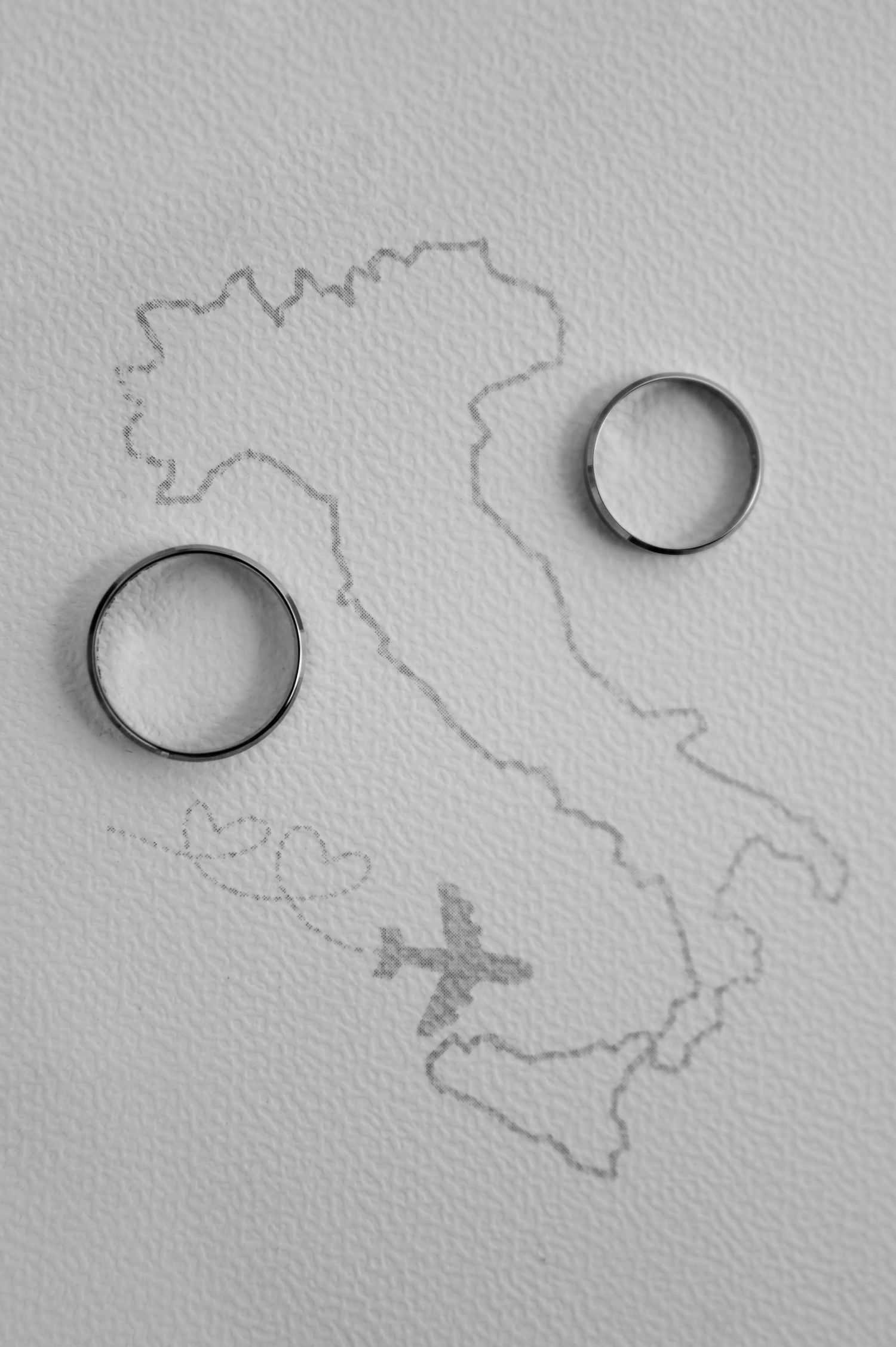 Obrączki ślubne na tle mapy Włoch z zaznaczoną Sycylią – detale ślubne na romantycznym weselu we Włoszech, ślub na Sycylii.
