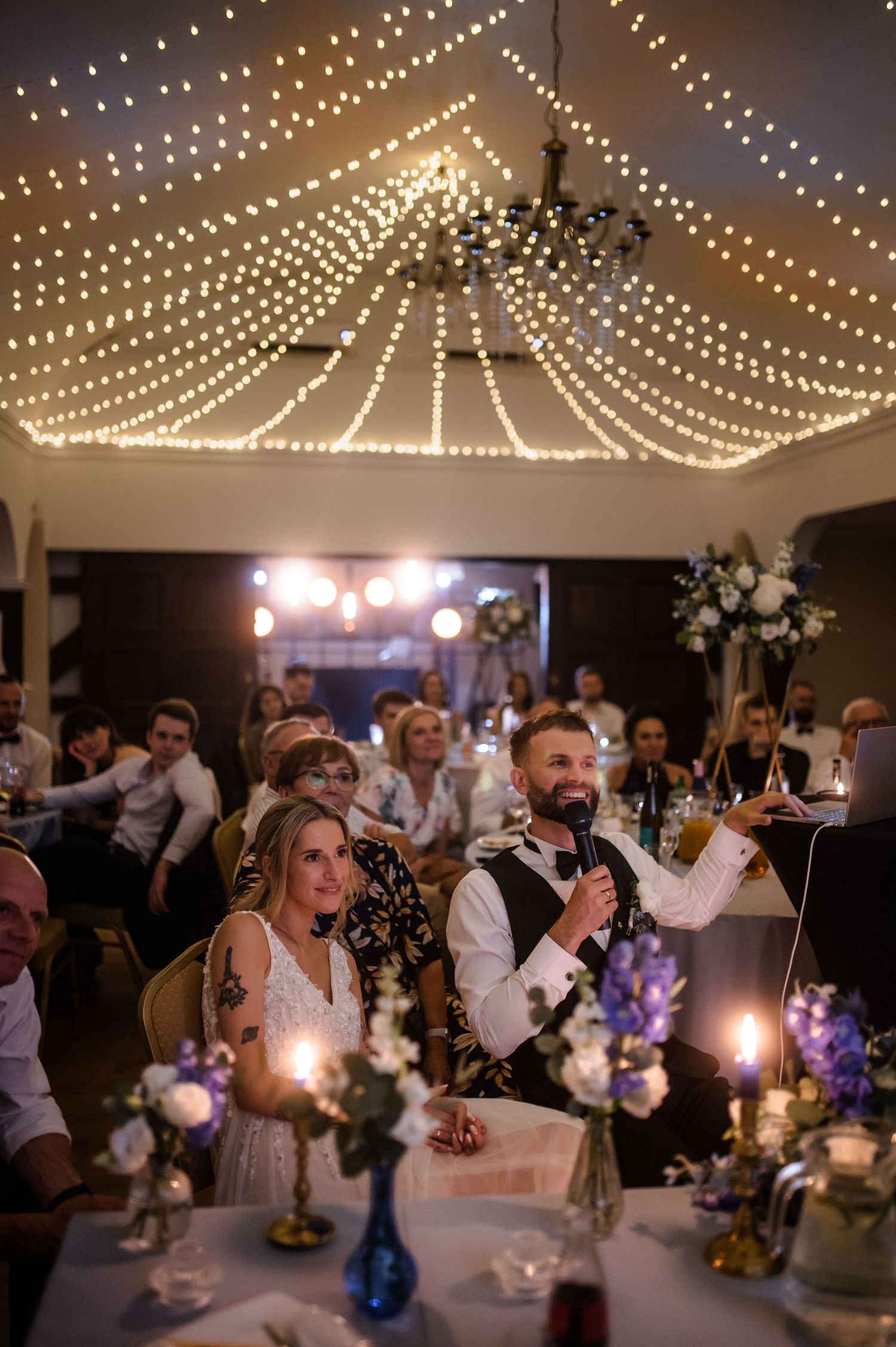 Para młoda z rodziną podczas eleganckiego wesela w Gdańsku, Restauracja Ołowianka, girlandy świetlne w tle.