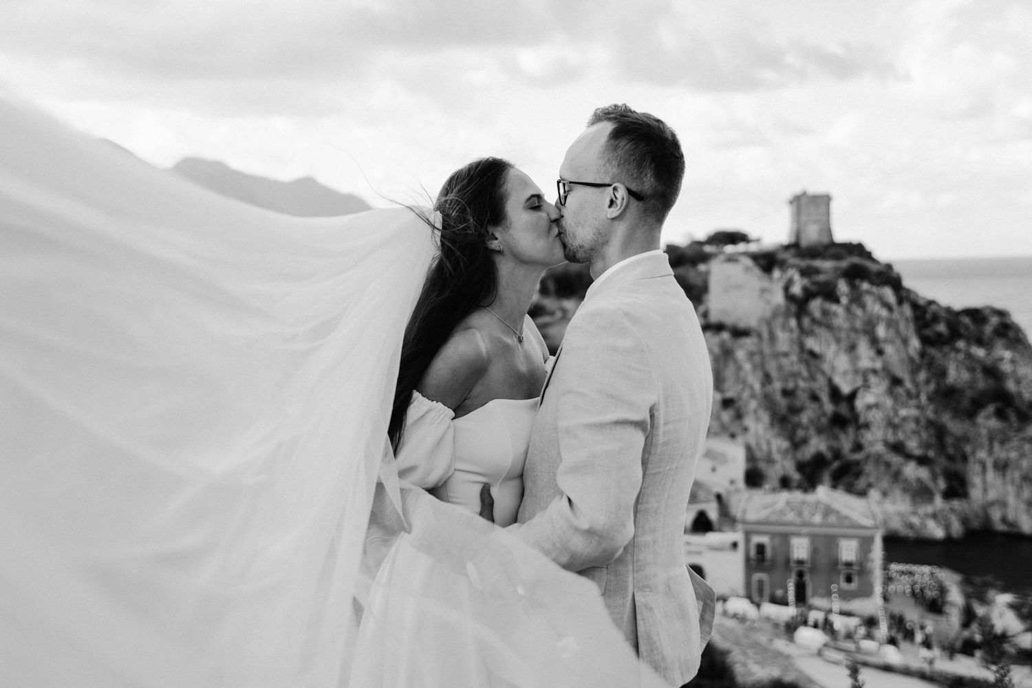 Zdjęcie zakochanych w objęciach na tle skał i ruin Tonnary di Scopello