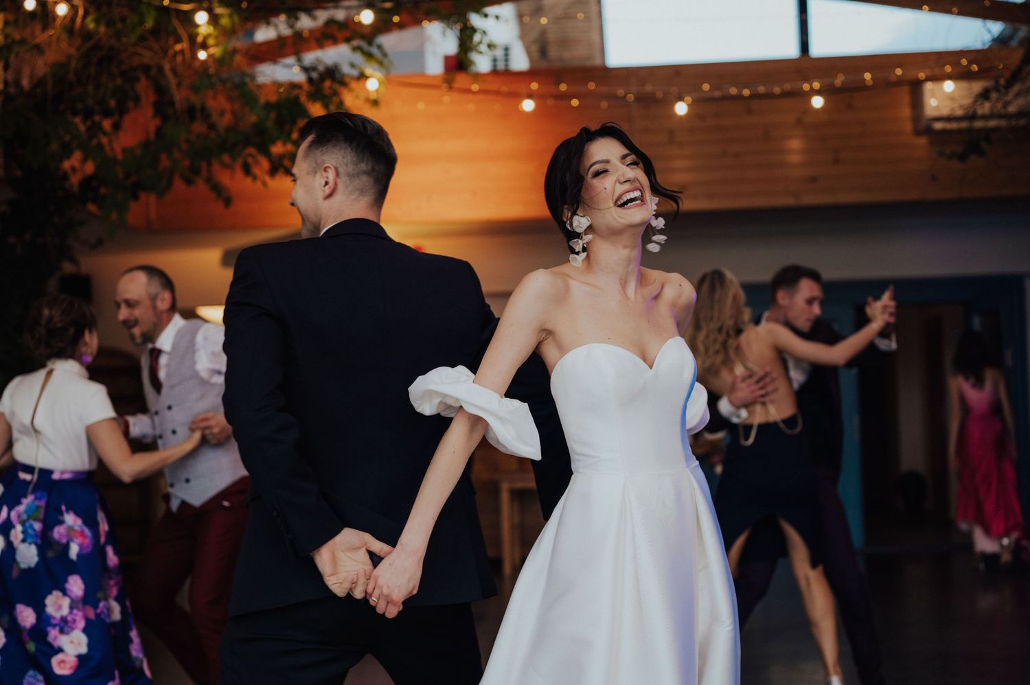 Radosny taniec pary młodej wśród gości, pełen energii i swobody.