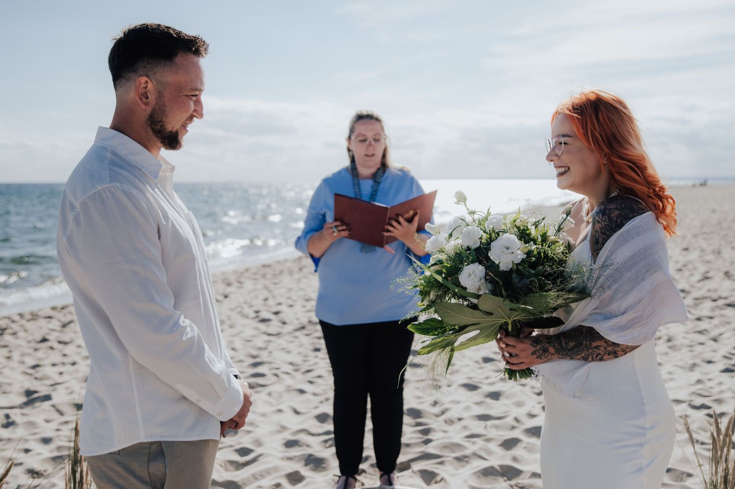 Ślub cywilny na plaży, Para Młoda wymieniająca spojrzenia podczas ceremonii nad brzegiem morza