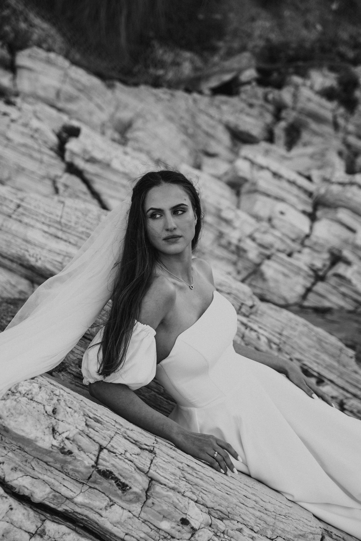 Portret panny młodej na tle sycylijskich skał – eteryczny, minimalistyczny kadr o eleganckim charakterze.