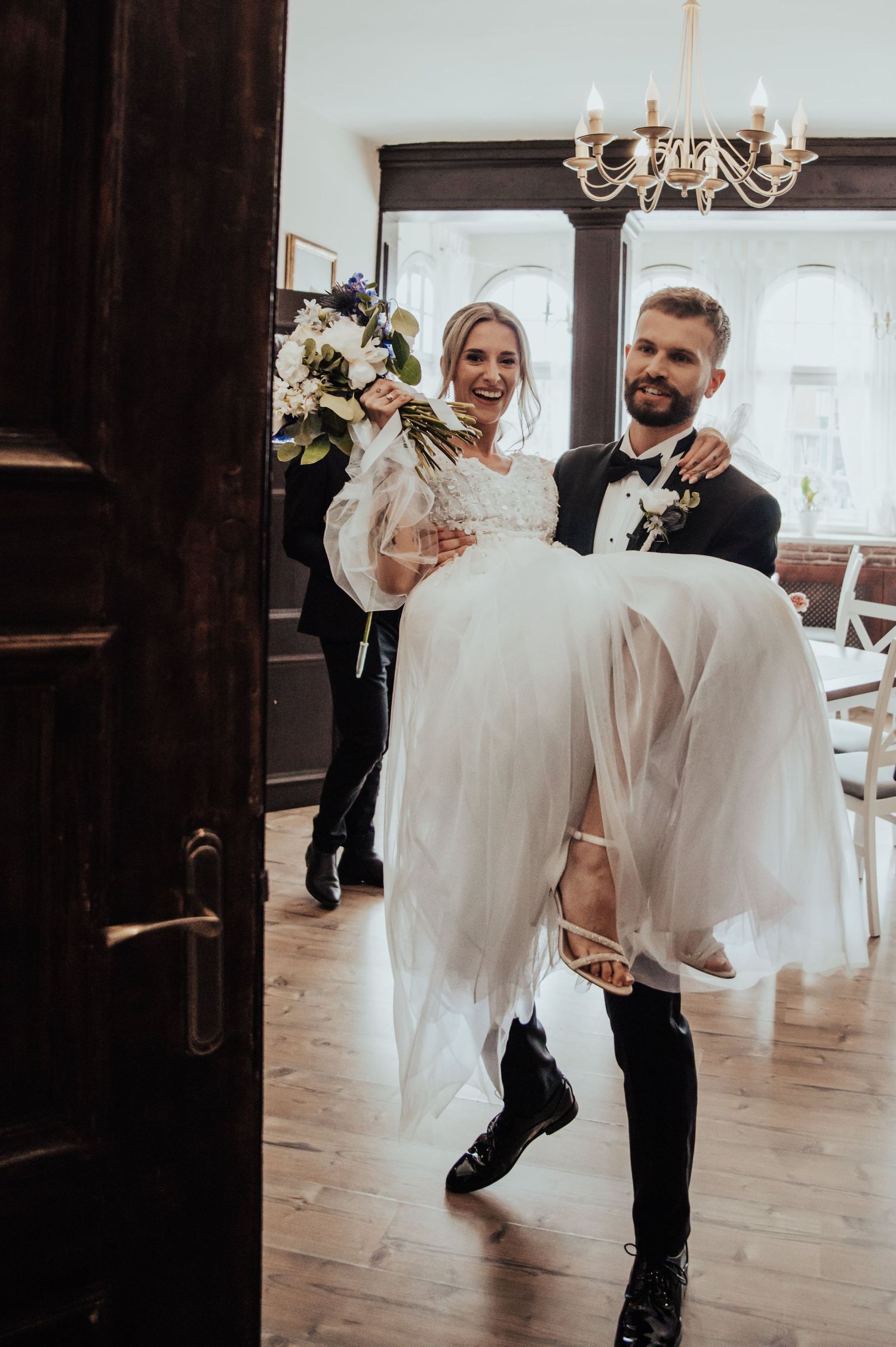 Pan Młody wnosi Pannę Młodą do sali weselnej – radosne powitanie Pary Młodej w Gdańsku