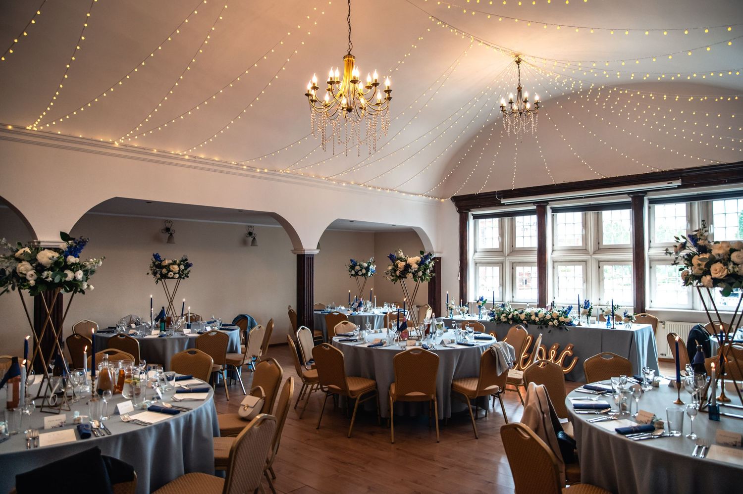 Sala weselna w Restauracji Ołowianka w Gdańsku – eleganckie dekoracje w bieli i niebieskim, świece i girlandy świetlne