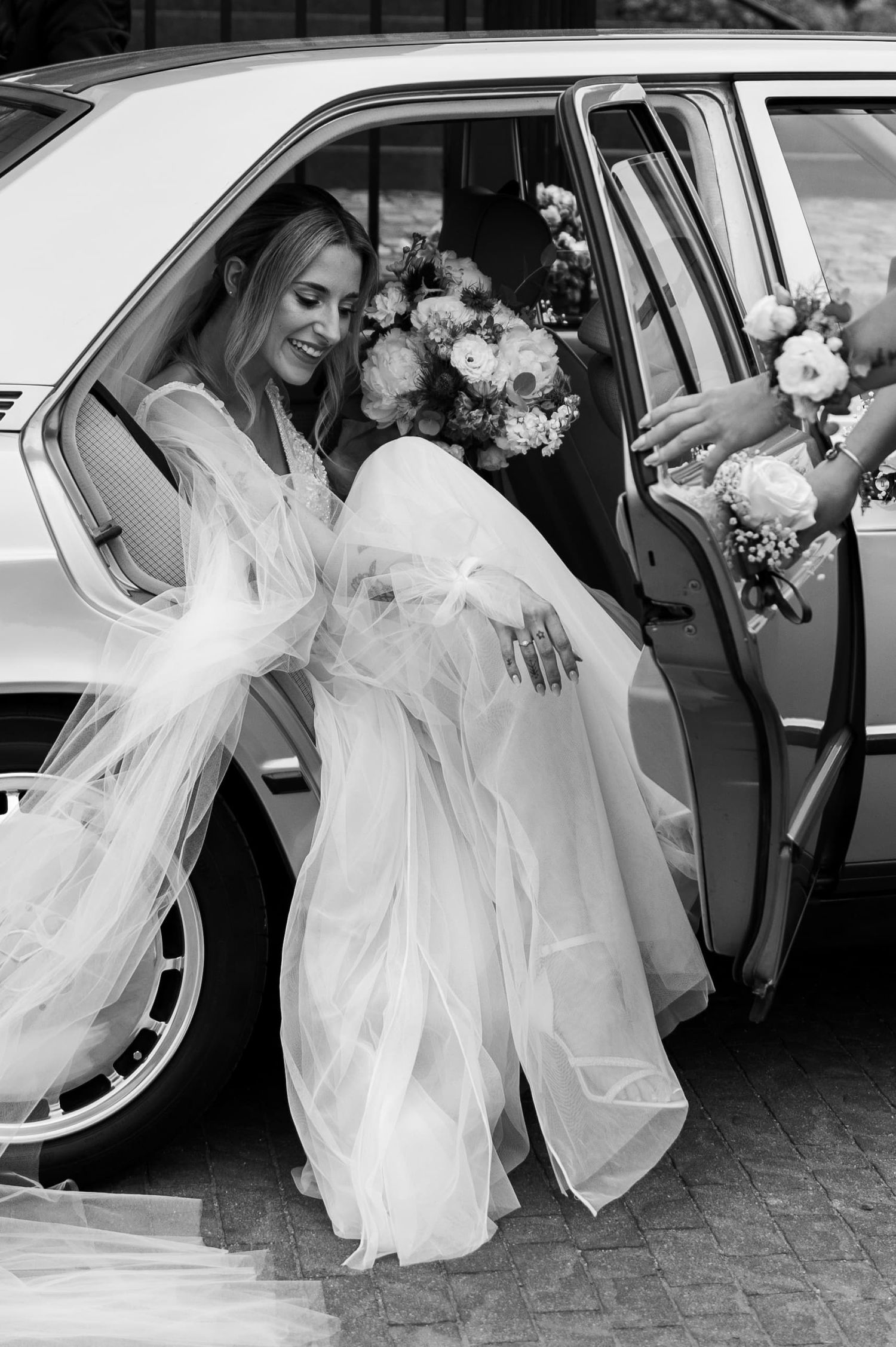Panna młoda w Gdańsku wysiada z eleganckiego auta Mercedes do ślubu.