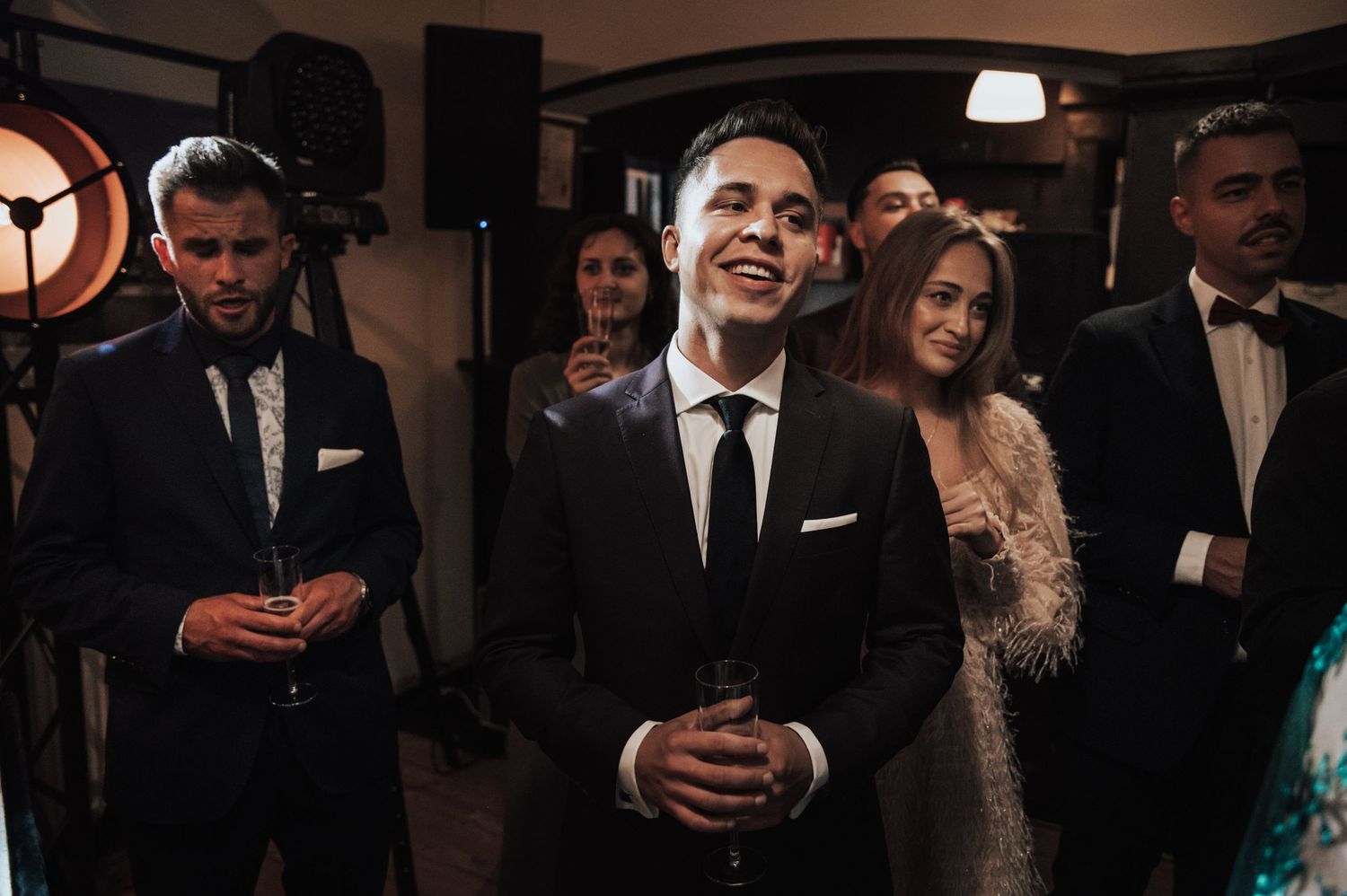 Zdjęcia gości weselnych w eleganckich stylizacjach – toast podczas przyjęcia ślubnego w Gdańsku