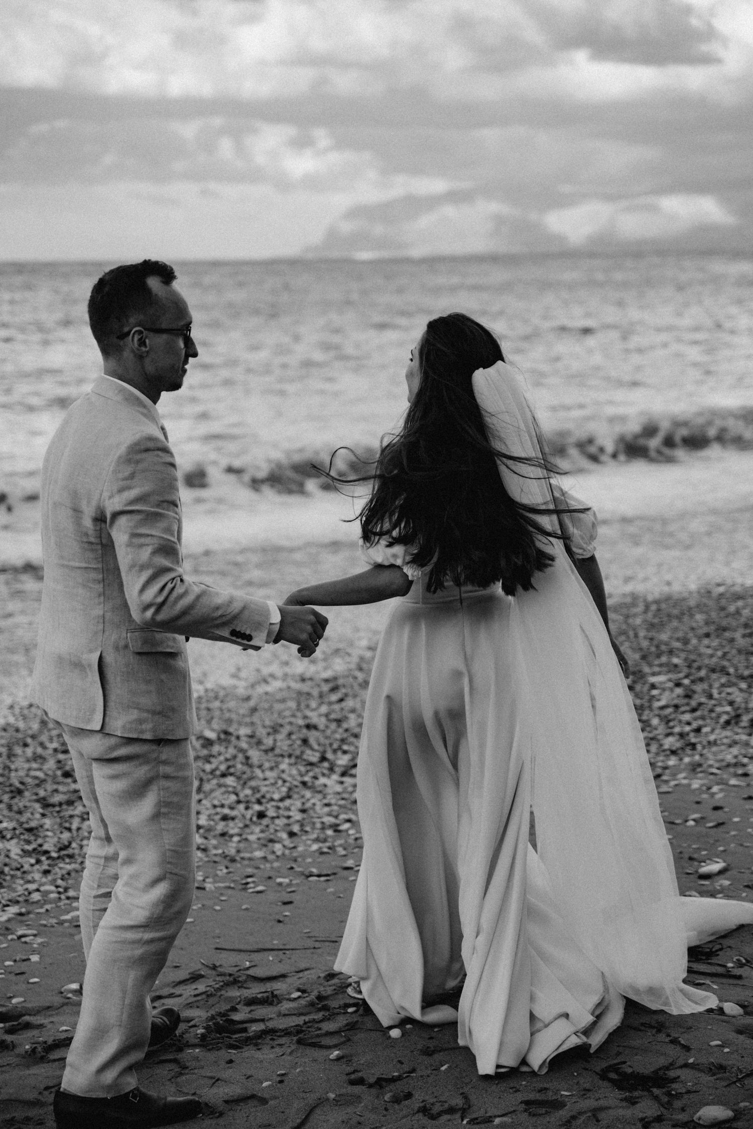 Para trzymająca się za ręce nad brzegiem morza – naturalna i eteryczna fotografia ślubna