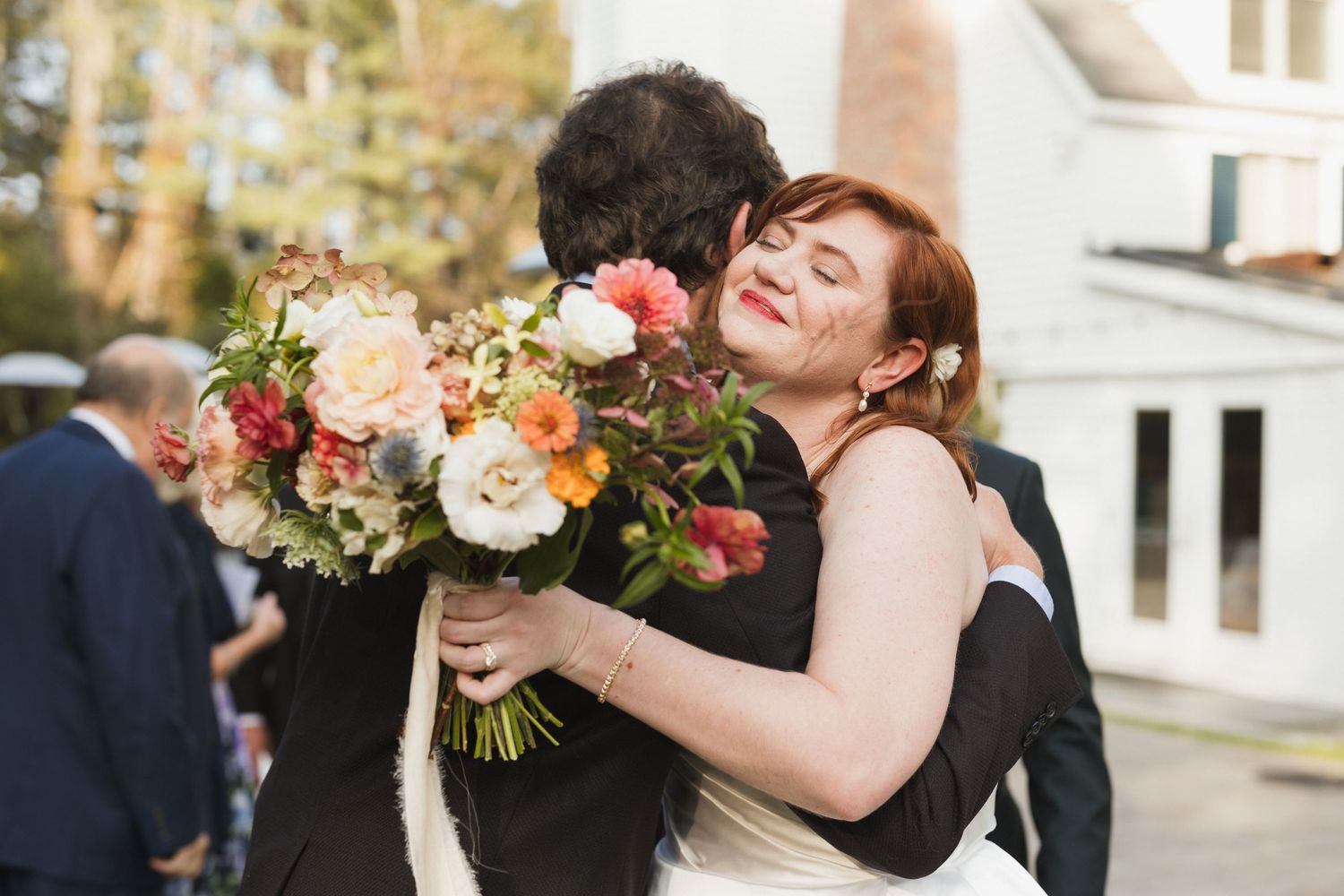 Bride gives a loving hug to a guest during cocktail hour at the Inn at Weathersfield in Vermont