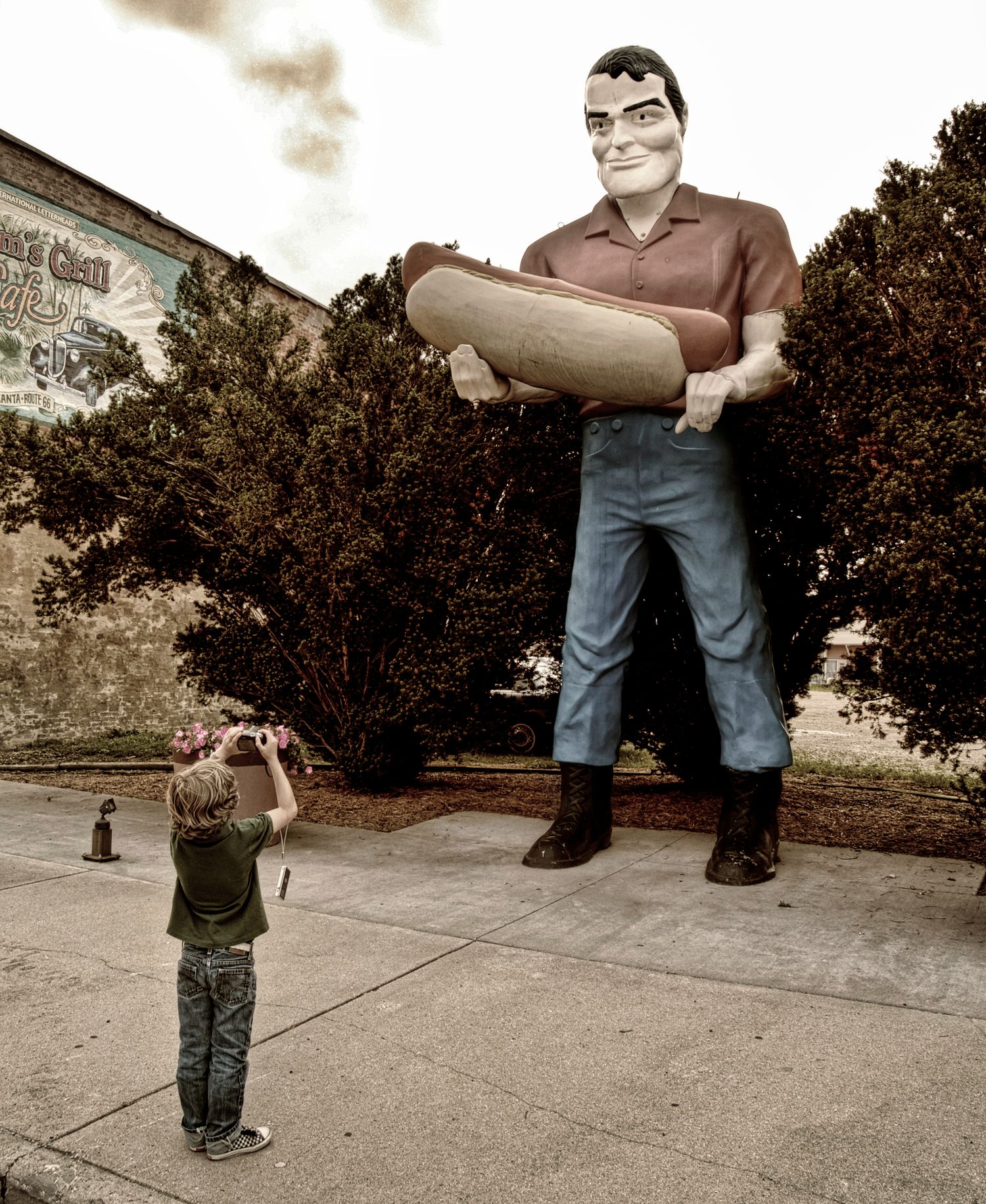 young boy photographing a giant