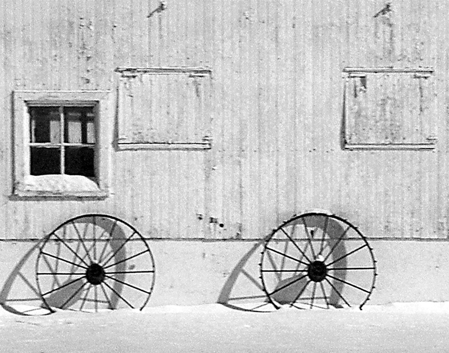 barn and wagon wheels in snow