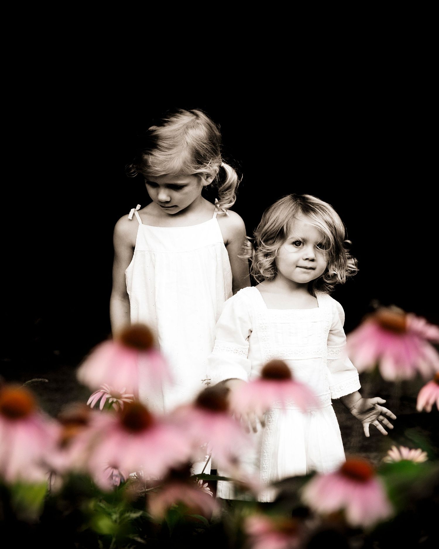 two children in front of vibrant flowers