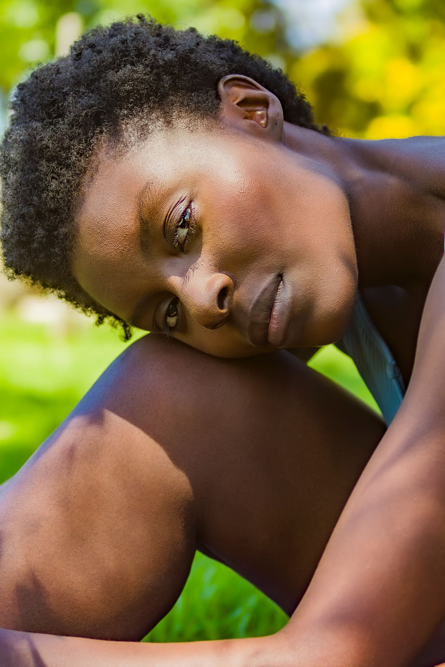 Close up portrait with natural sunlight and green foliage bokeh in the background.