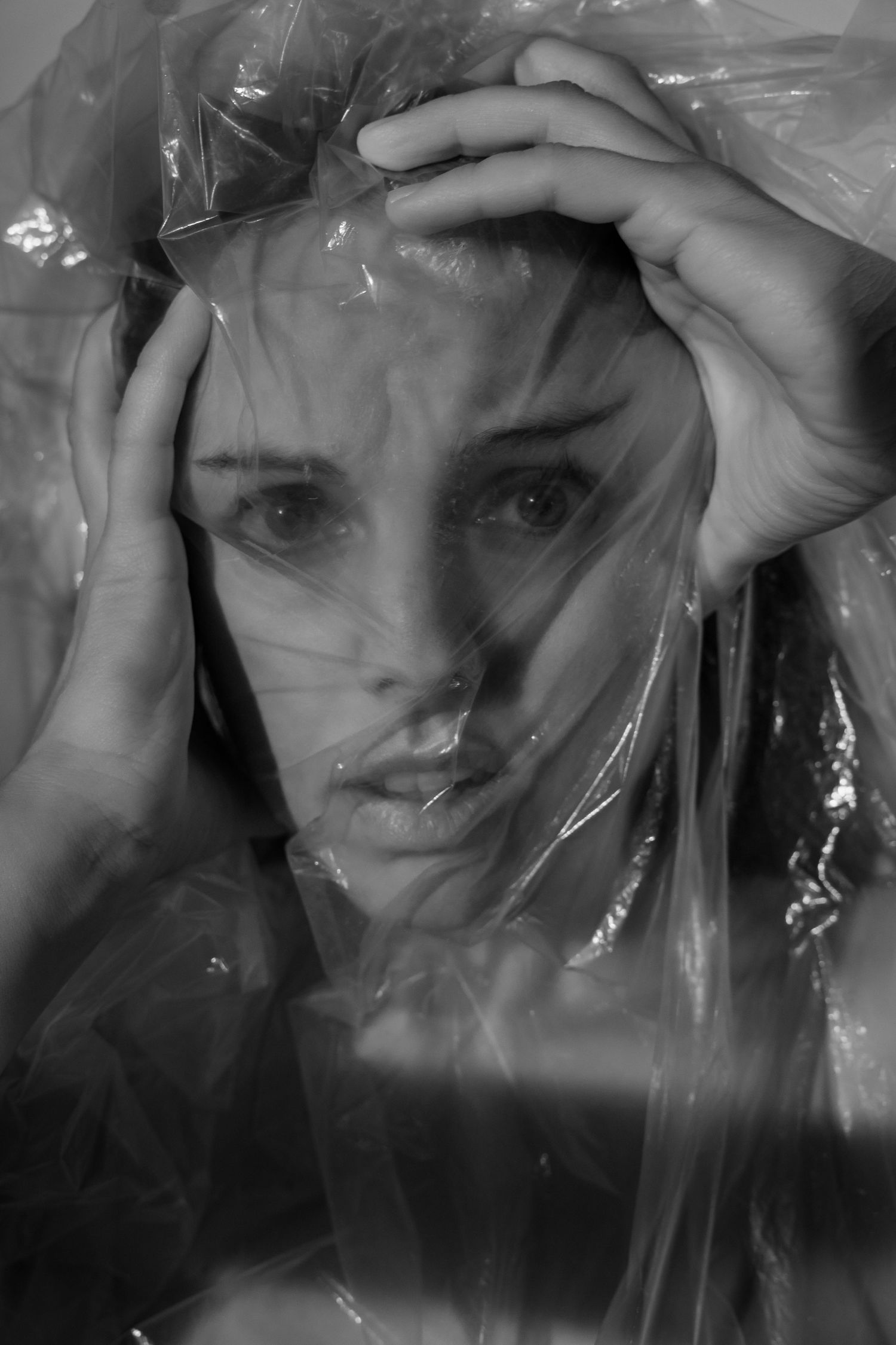 Abstract portrait series with plastic wrap creating distorted reflections and textures.