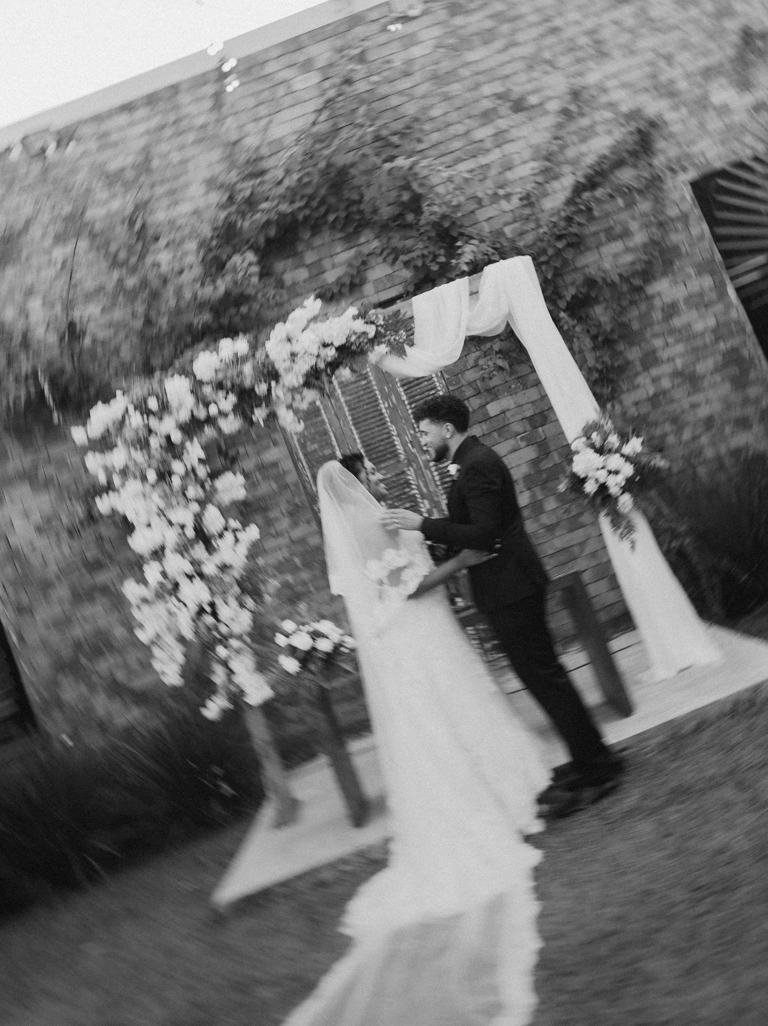 Black and white wedding photo capturing a romantic ceremony moment.