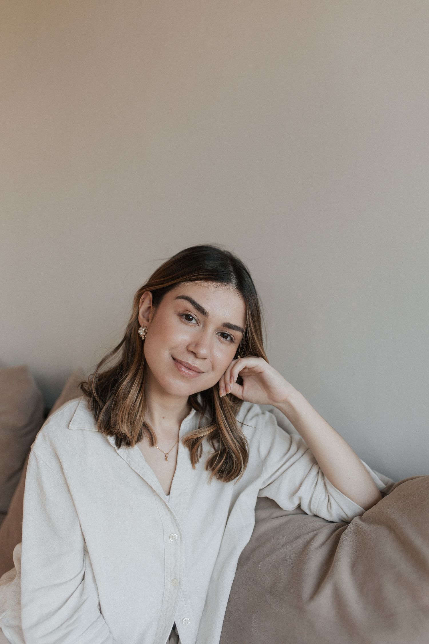 Lifestyle portrait series in a minimalist setting with natural lighting and cream colored clothing.