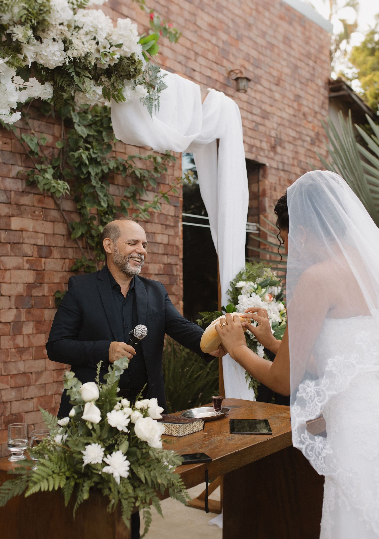 An outdoor wedding ceremony with white floral decorations and wooden accents.