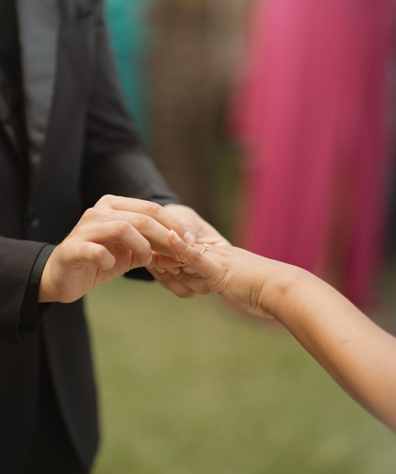 Close-up of hands joining together during a wedding ceremony exchange.