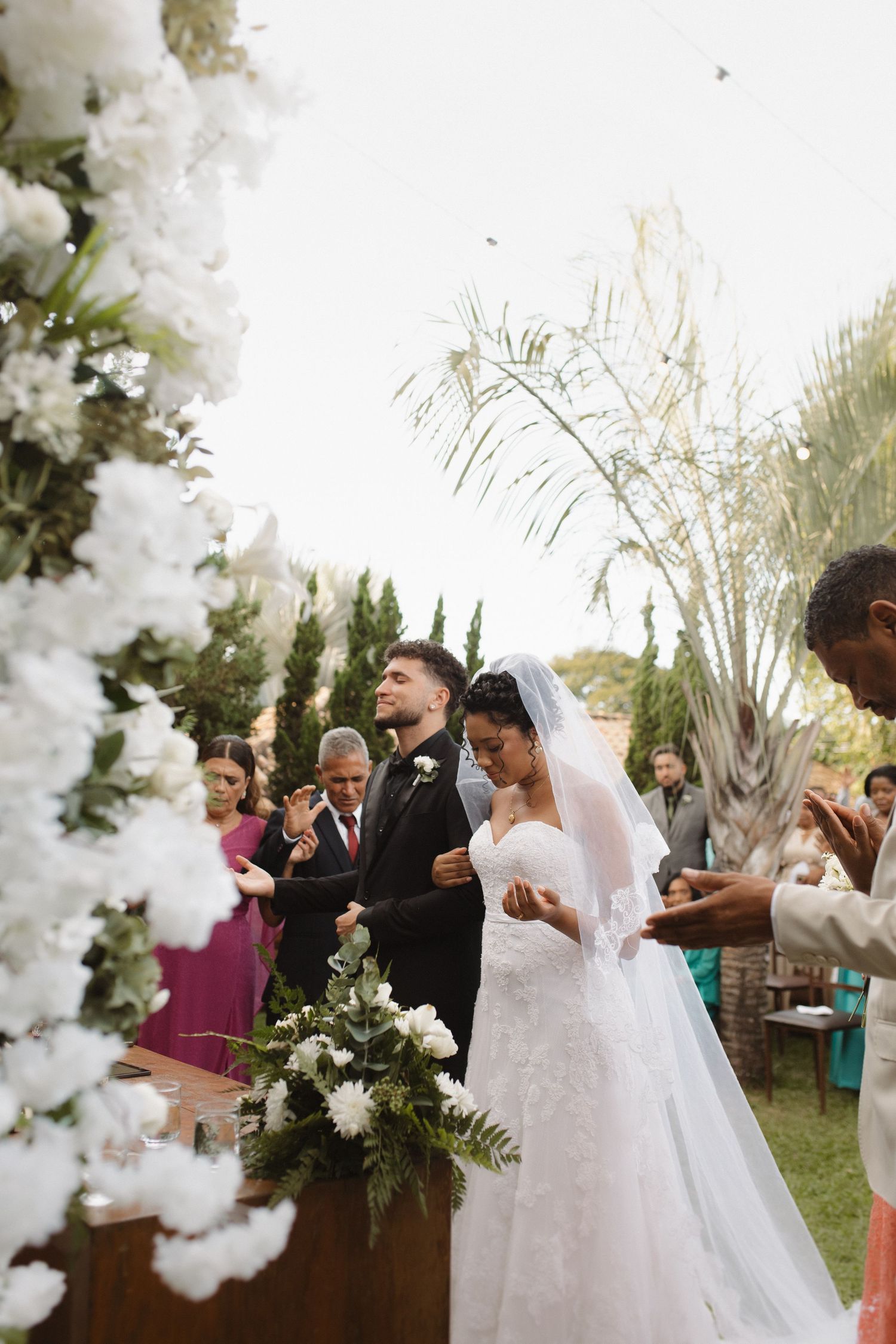Garden wedding ceremony with white floral decor and elegant arrangements.