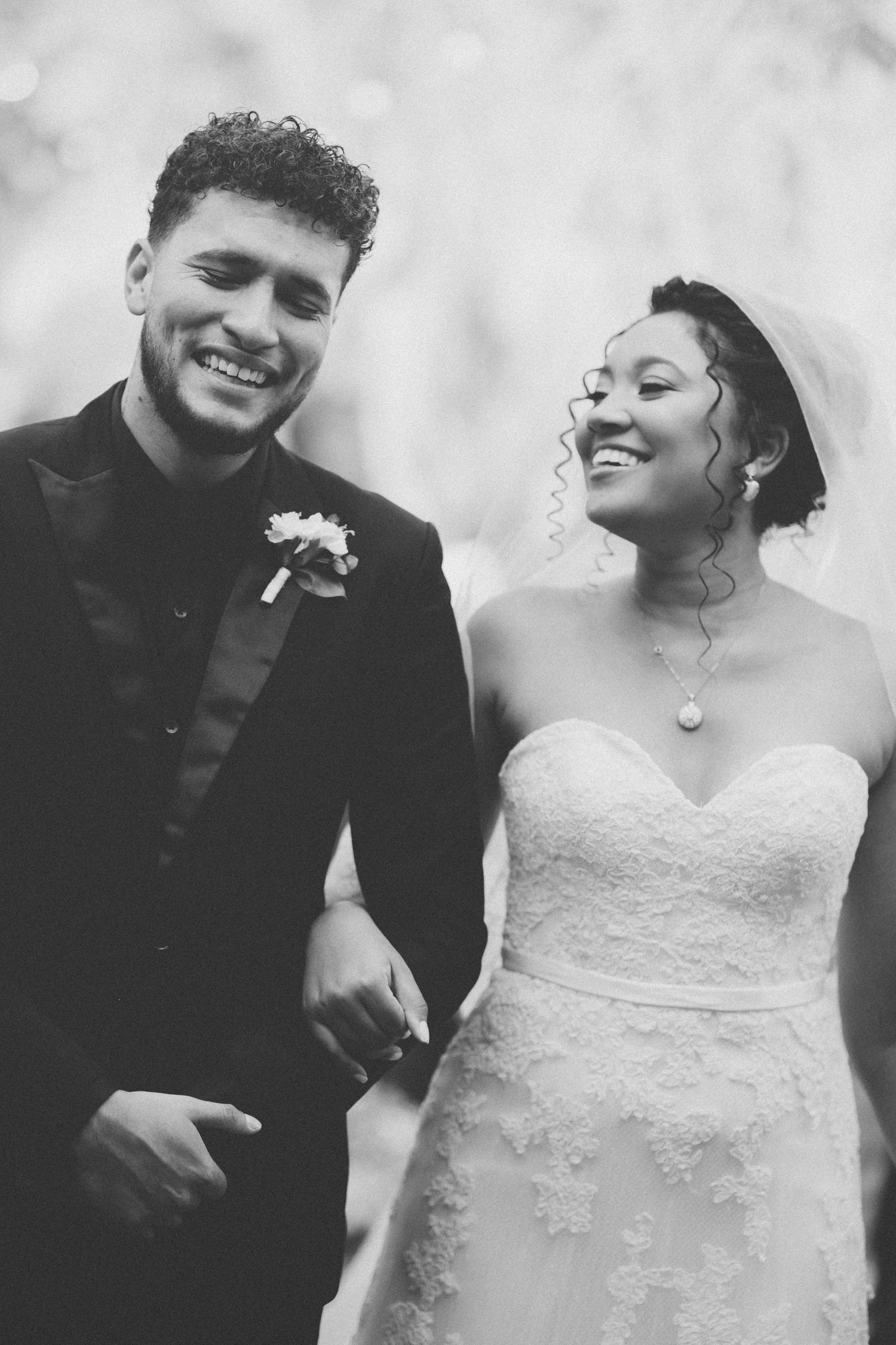 A joyful black and white wedding portrait capturing a candid moment of celebration.