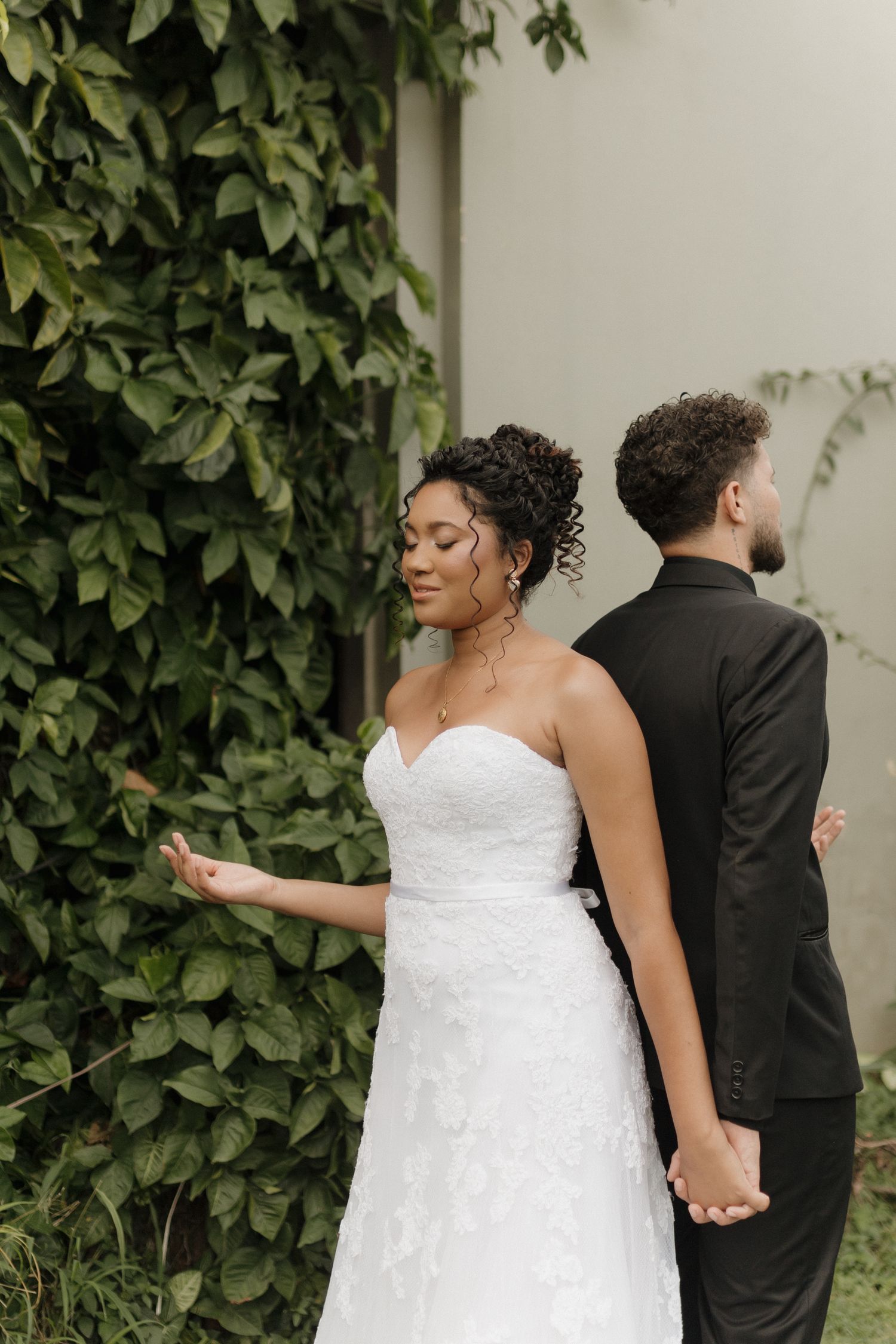 Romantic wedding portrait sequence against an ivy-covered wall in a garden setting.