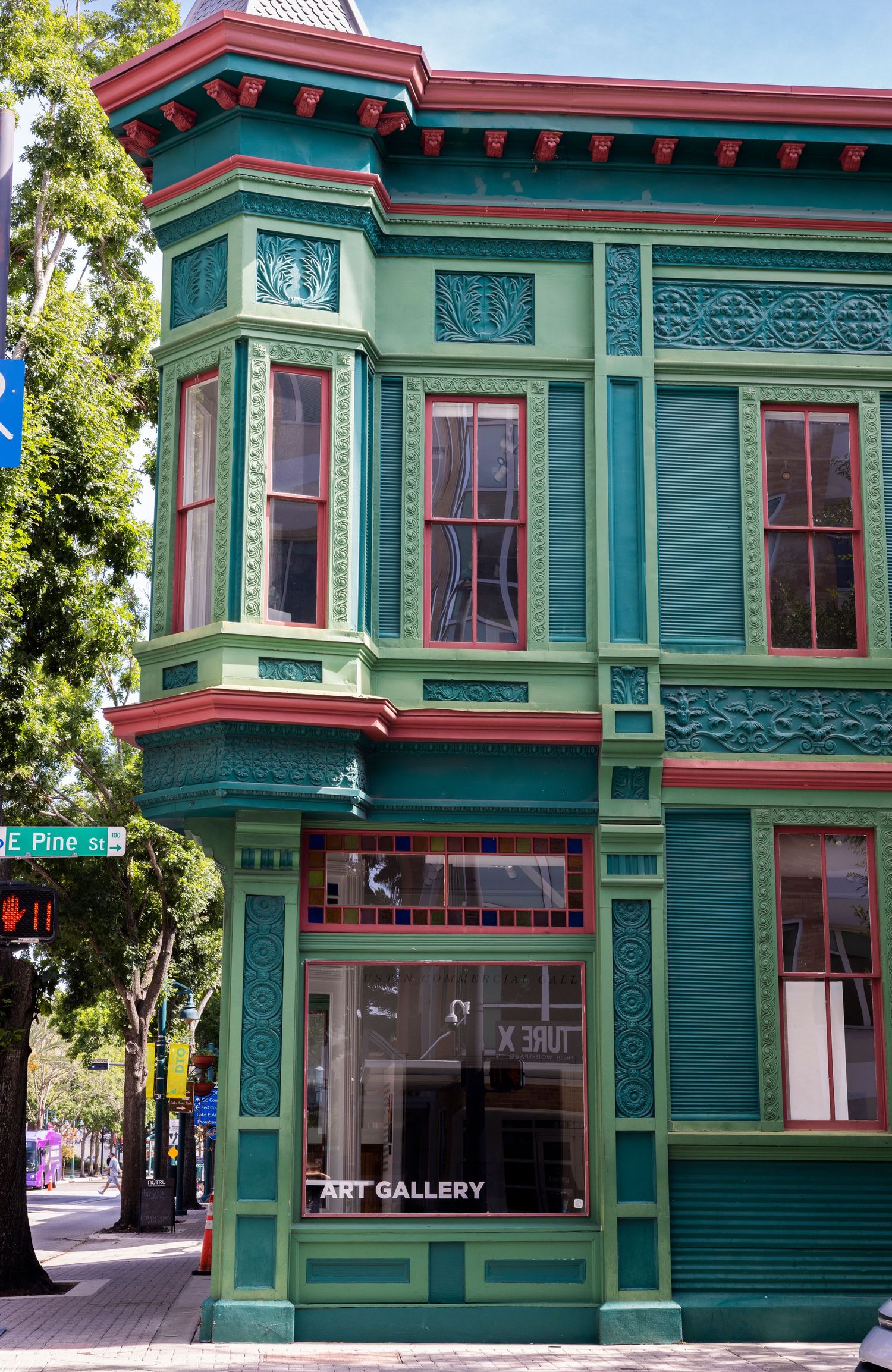 Ornate green Victorian-style corner building housing an art gallery on Pine Street.