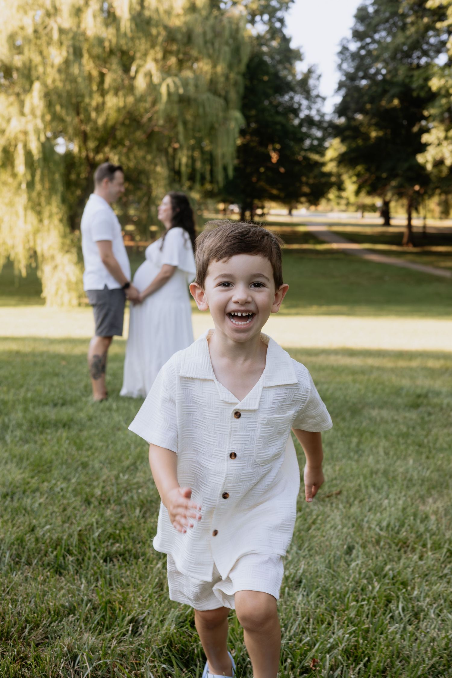 A series of candid outdoor photos showing a child in white clothing playing and running in a grassy field on a sunny day.