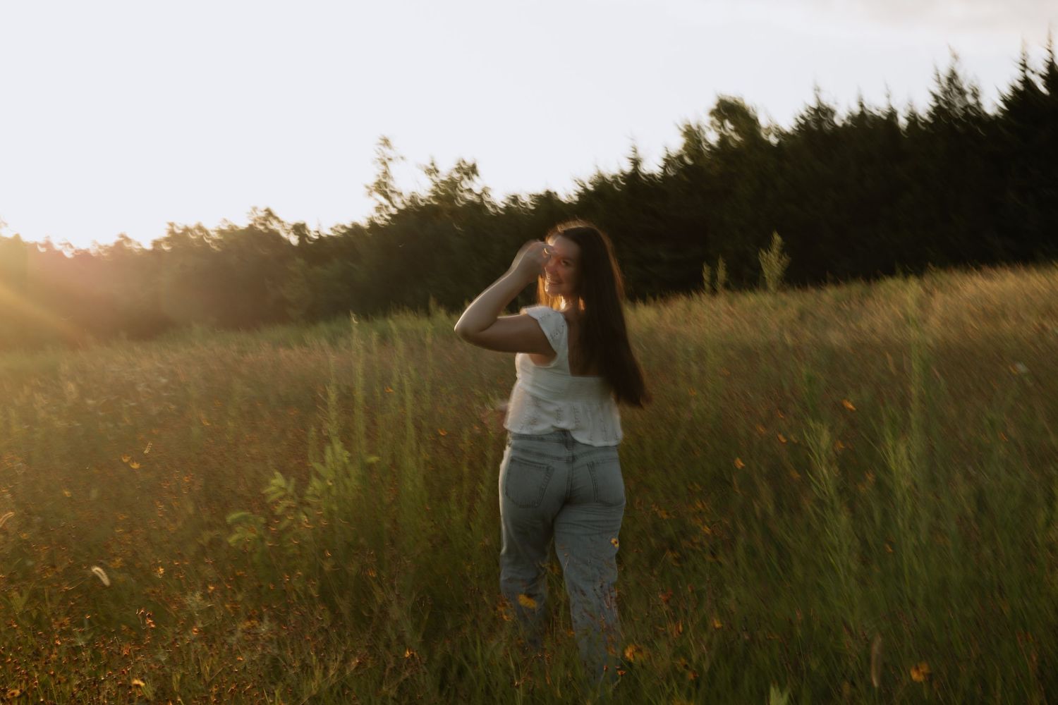 Person photographing in golden field during sunset.