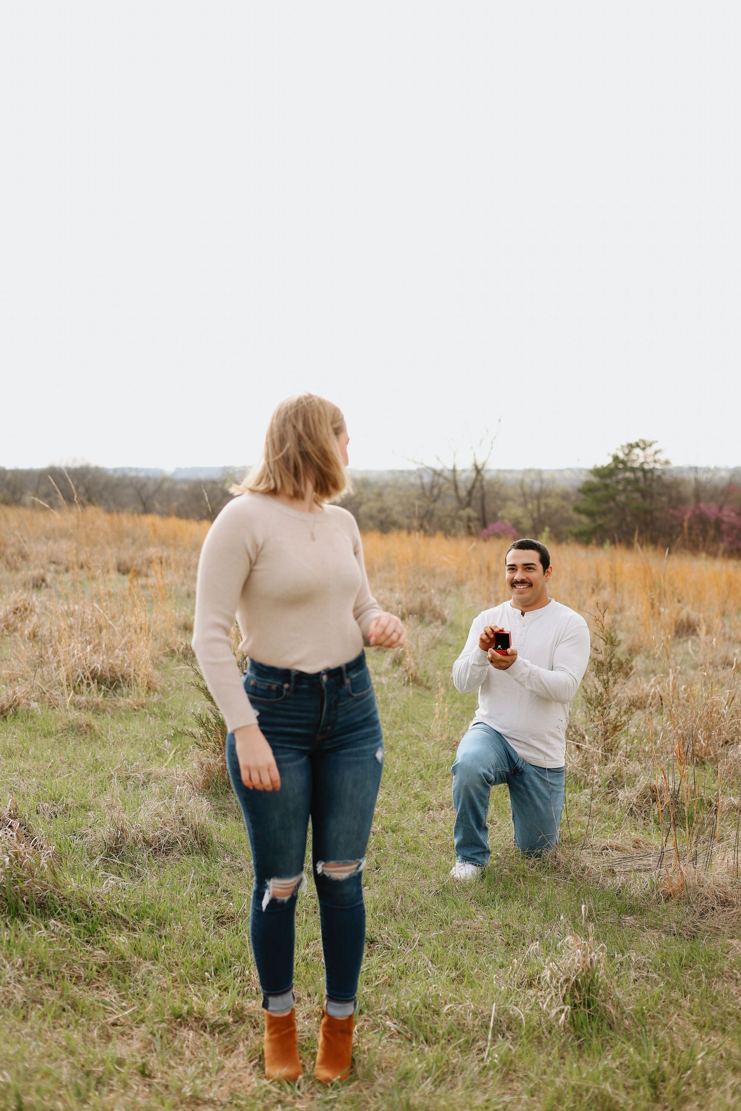 A couple shares a tender moment in a golden autumn field during a photo session.