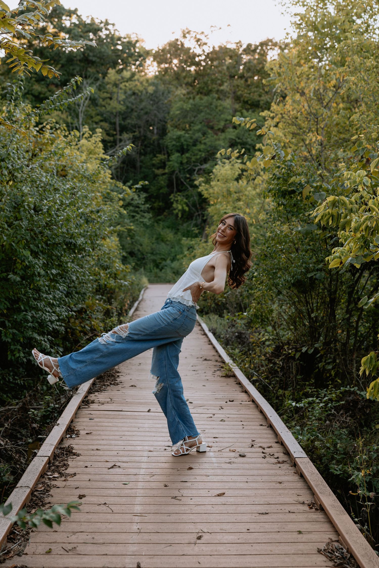 Playful poses on a wooden boardwalk surrounded by autumn foliage.