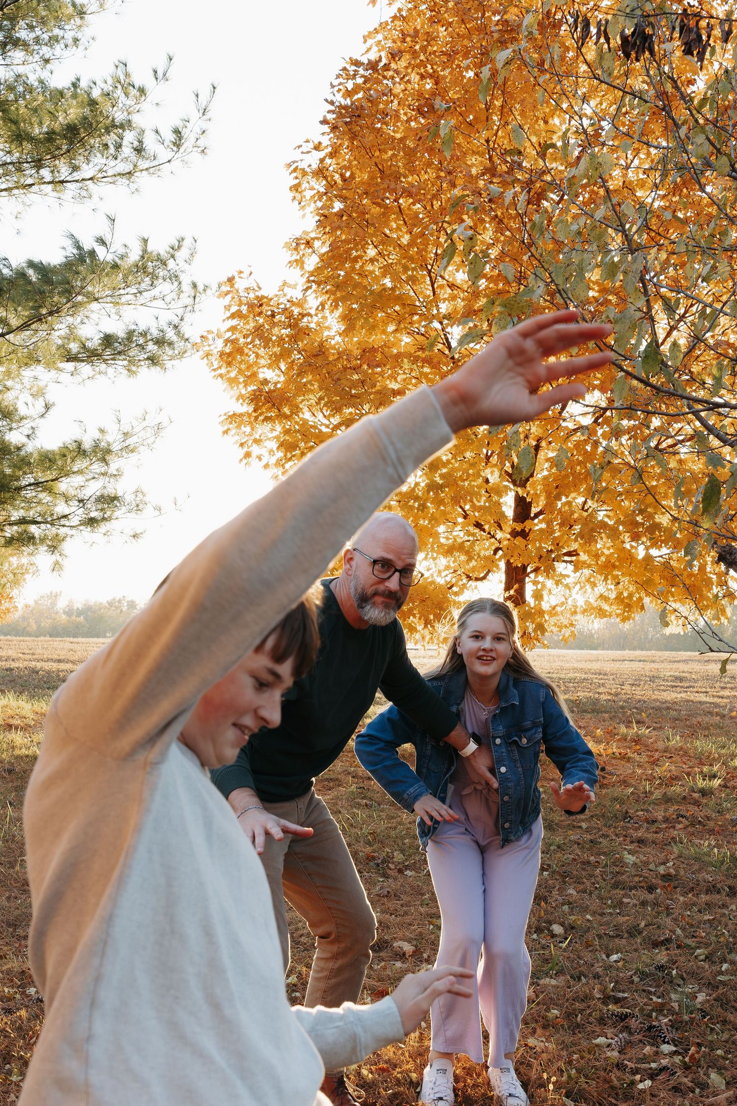 A sequence of playful poses in a park during autumn with golden leaves and trees in the background.