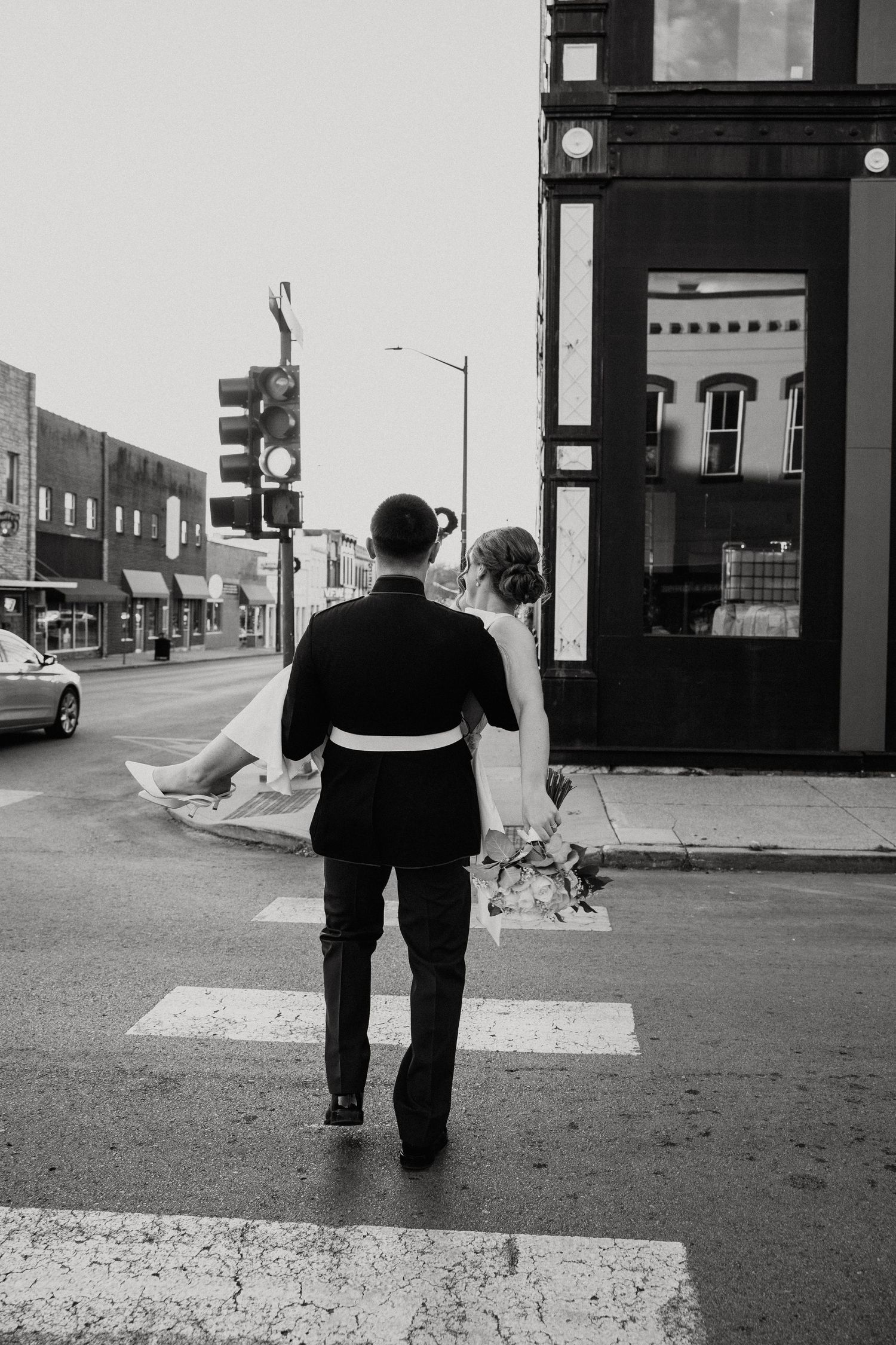 Couple walking away together on empty city street in black and white.