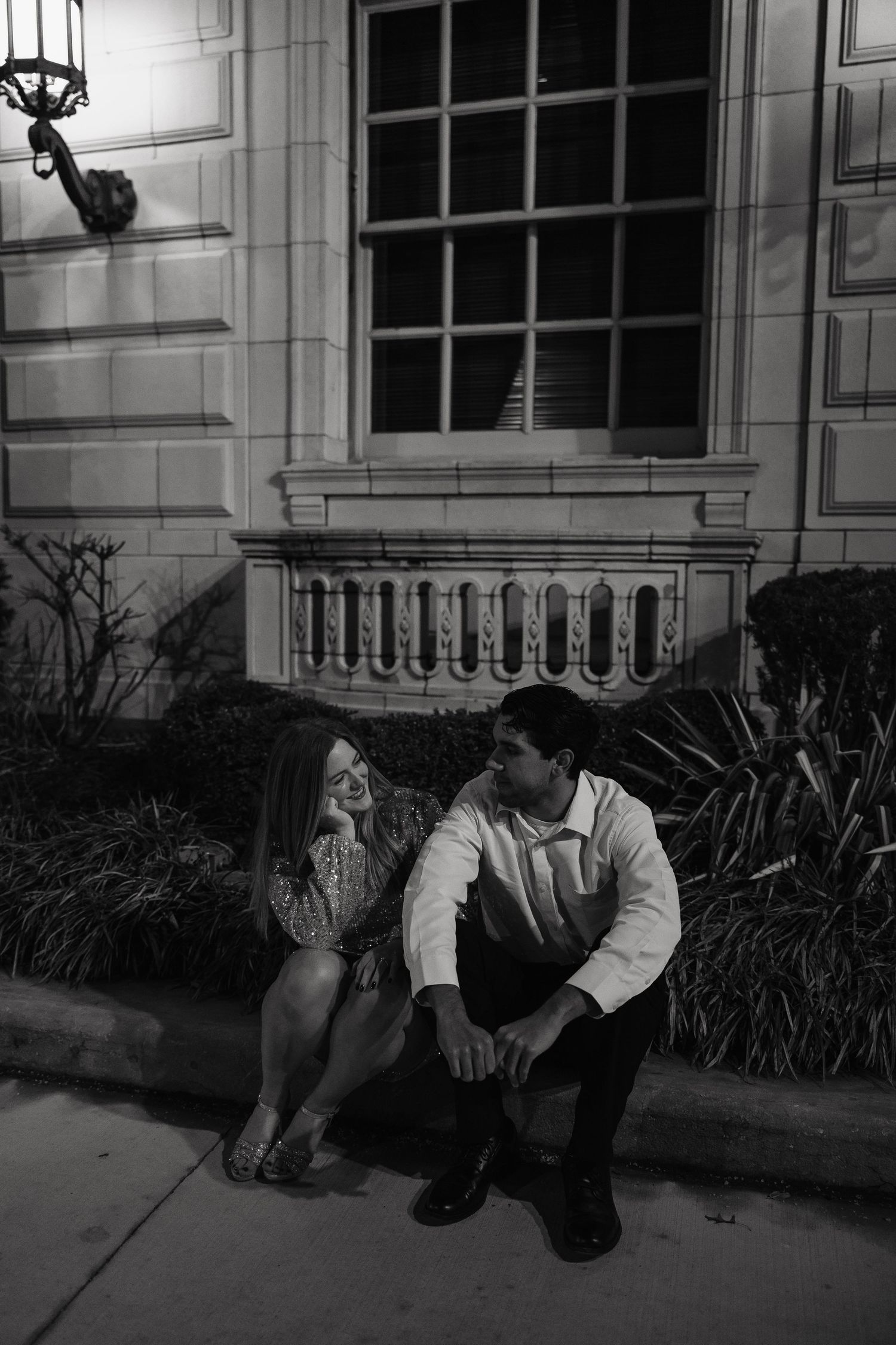 A black and white photo showing a couple looking at each other intimately.