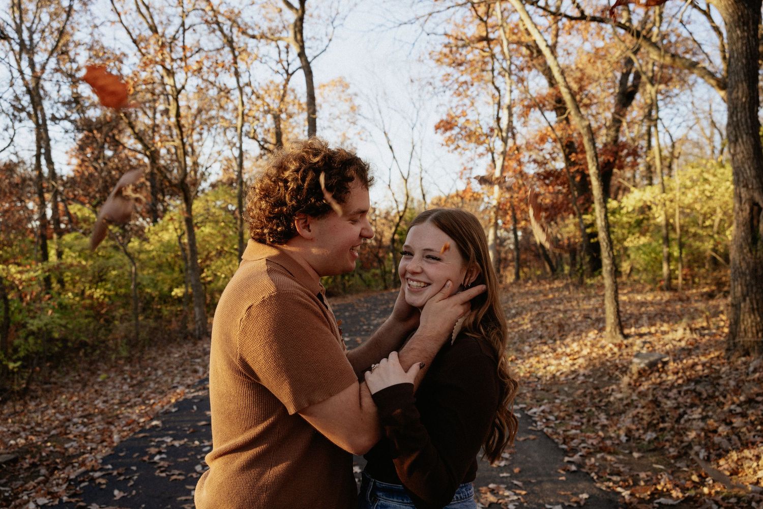 Romantic autumn scene with couple embracing among fall trees.