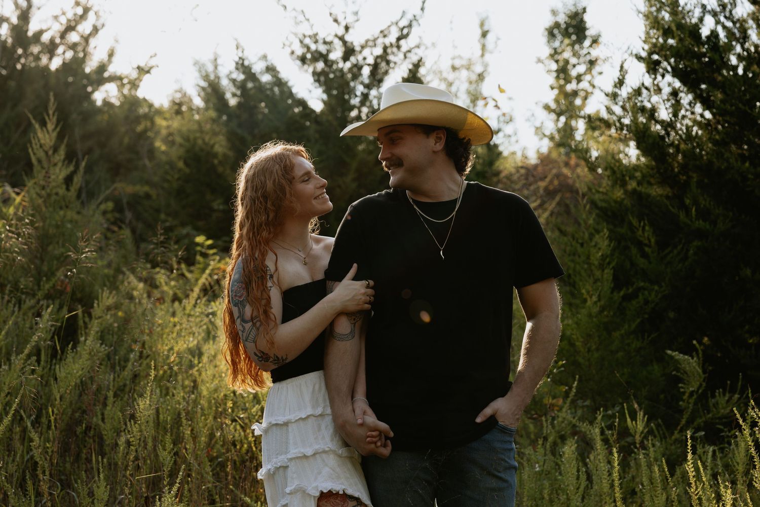A romantic sunset photoshoot in a field with natural lighting.