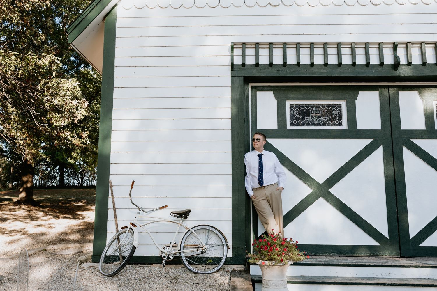 A vintage white building with green trim and a bicycle leaning against its exterior wall.