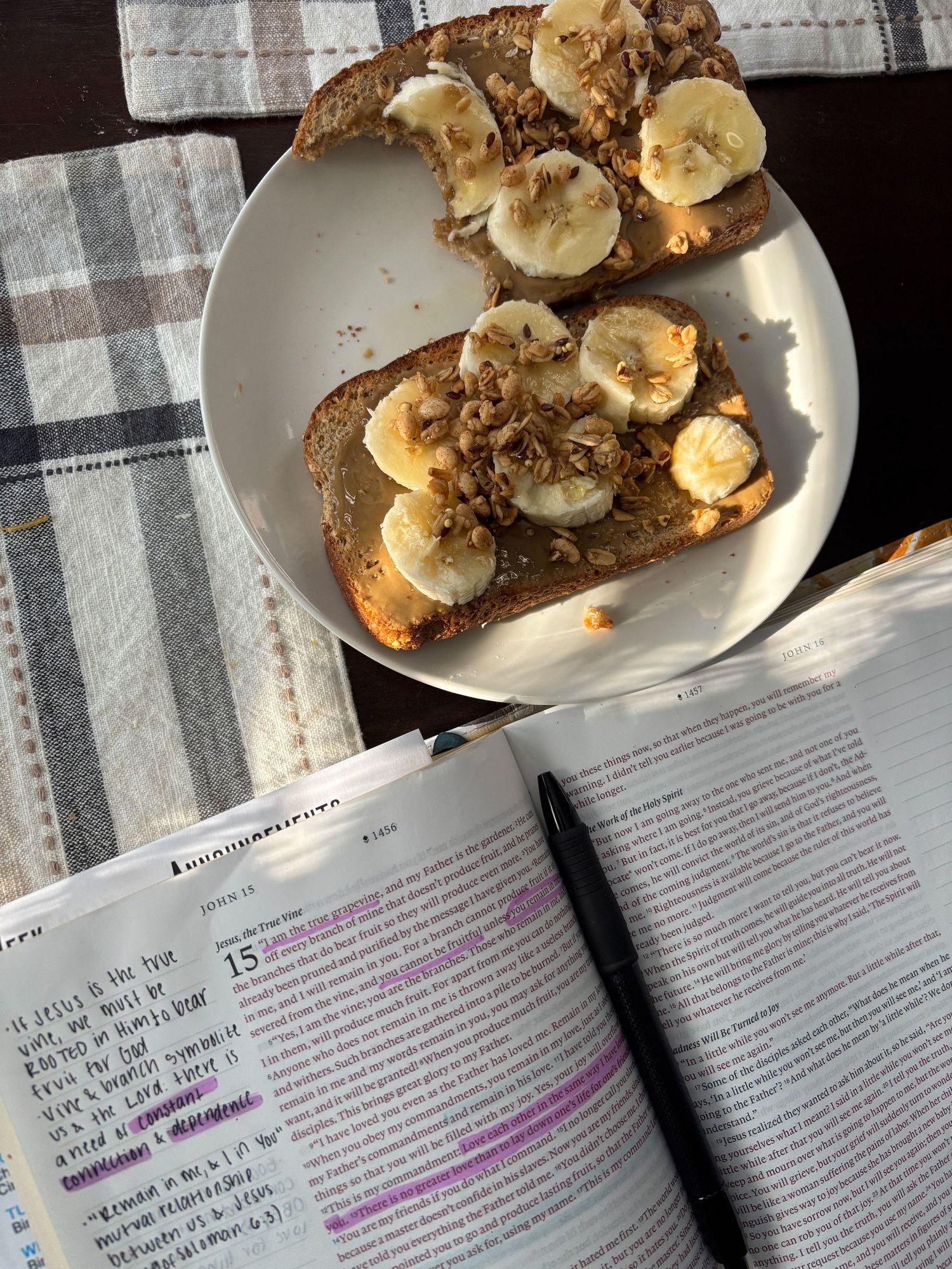 Sliced banana and nuts on toast with an open Bible in the background.