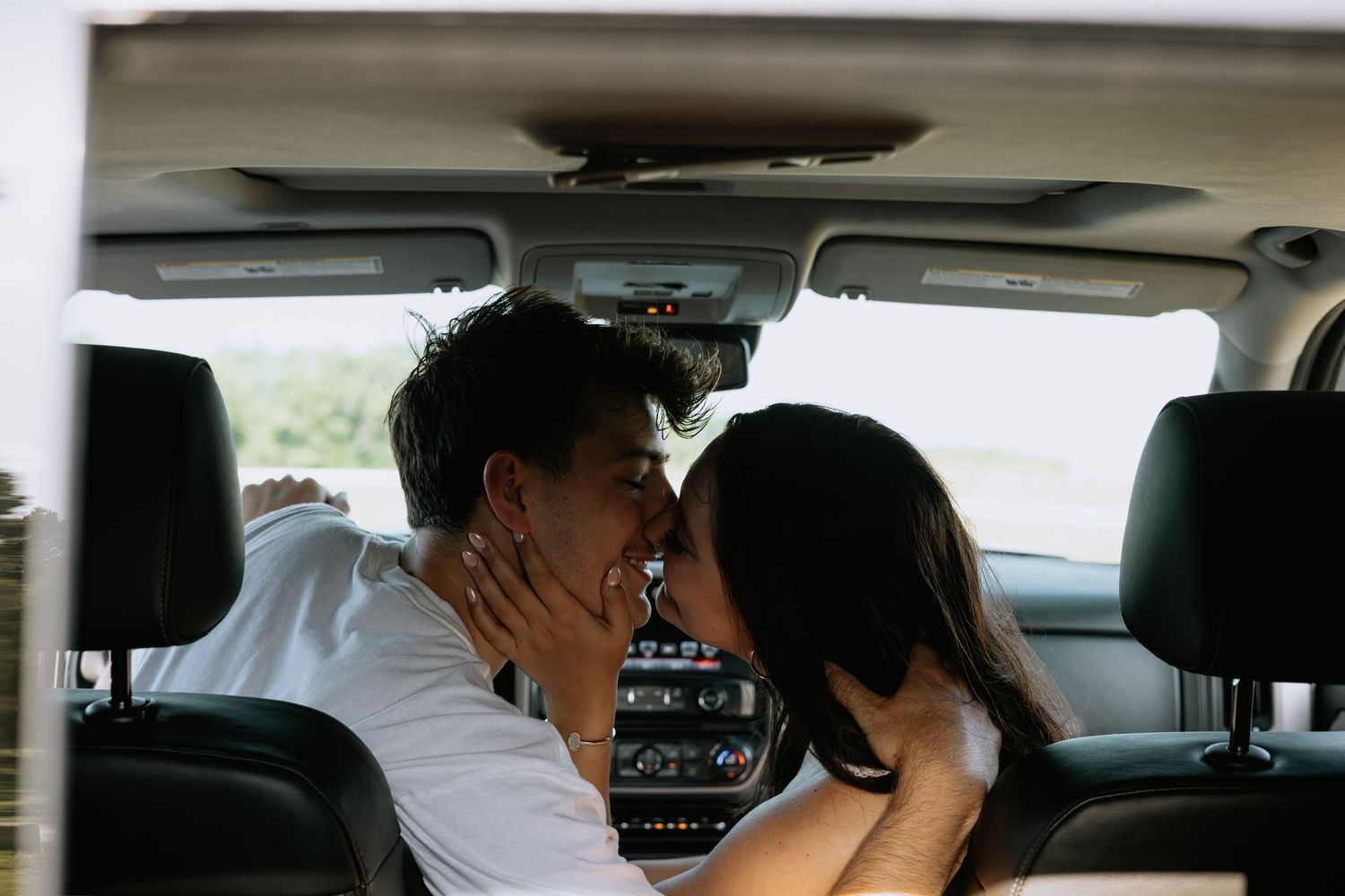 Couple shares intimate moment in cab of truck.