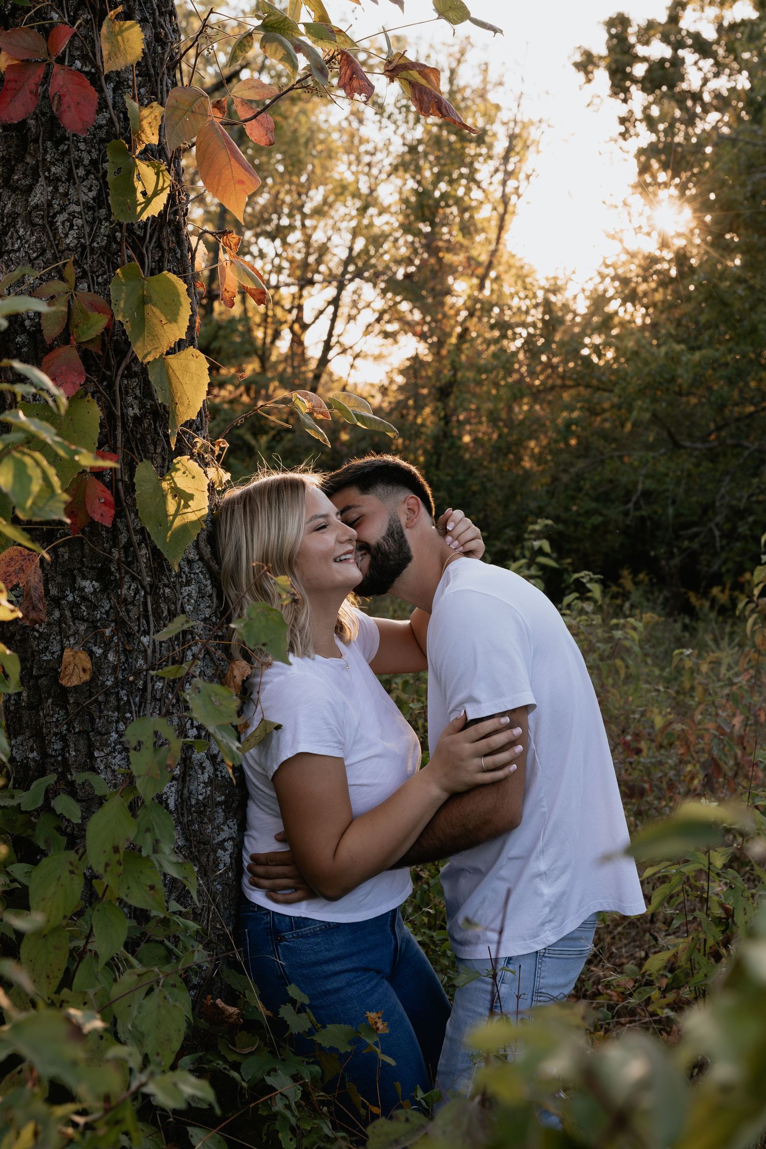 A tender moment shared between two people among autumn leaves.