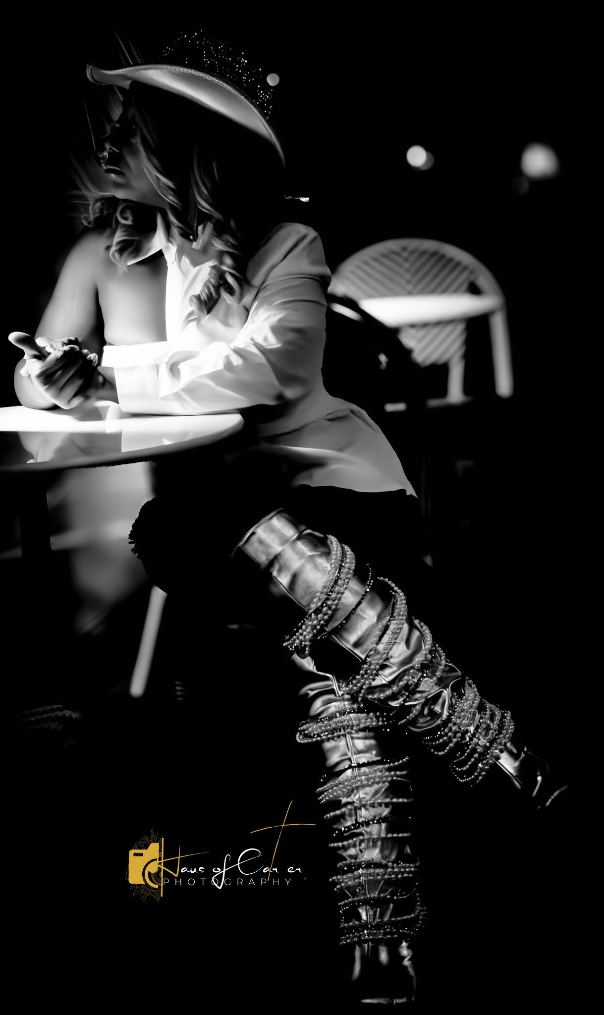 Artistic black and white fashion photo highlighting metallic boots in dramatic lighting.