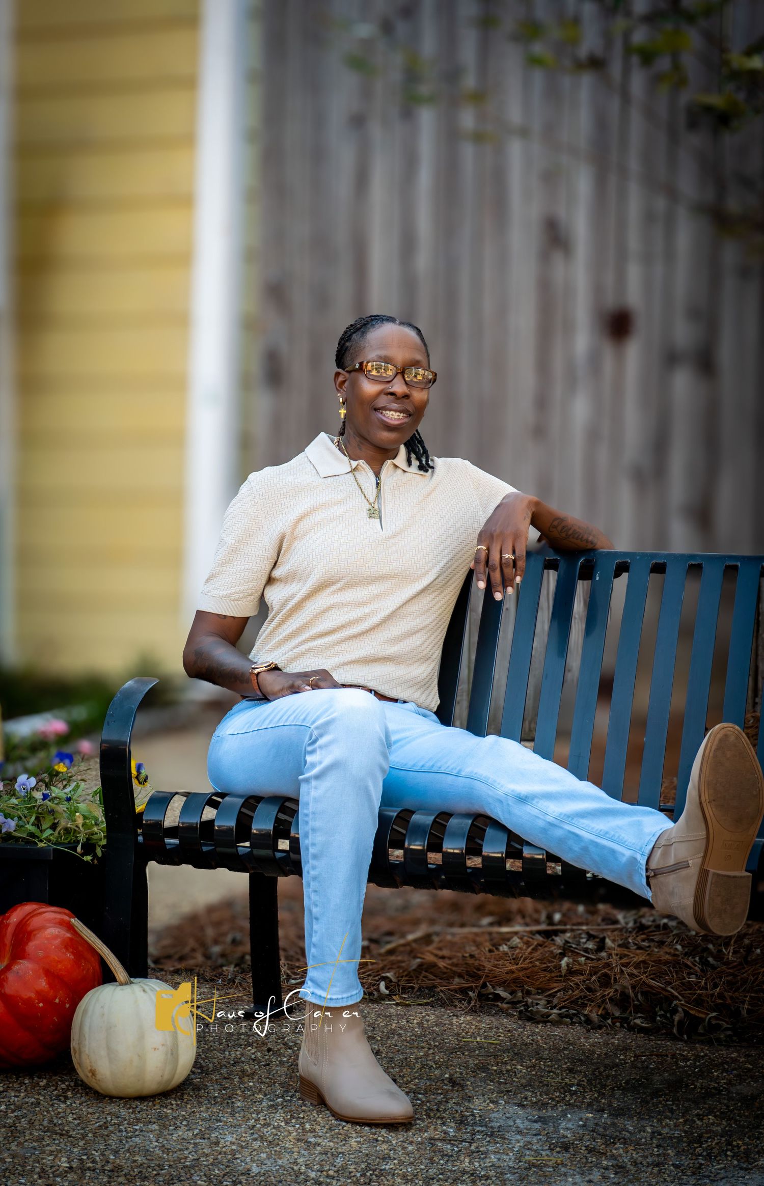 Casual outdoor portrait setting with pumpkins and bench in garden.
