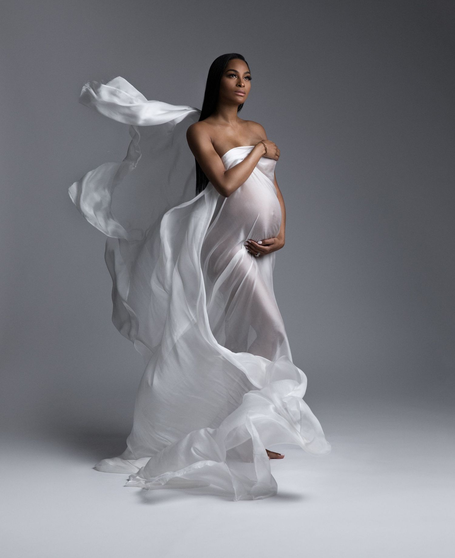 Artistic portrait series showing flowing white fabric movement against gray studio background.