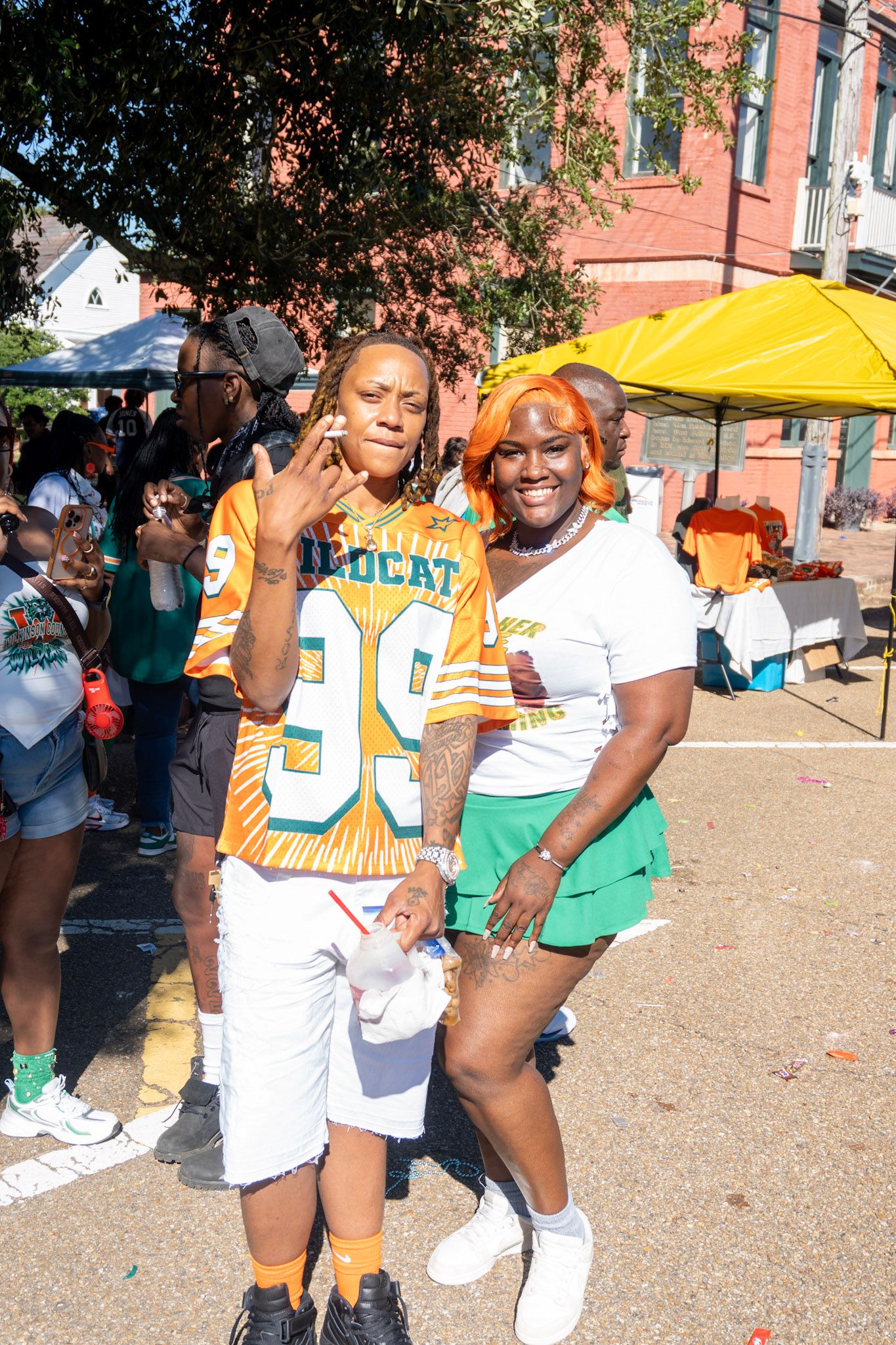 Outdoor event scene with yellow tent and sports jerseys in bright sunlight.