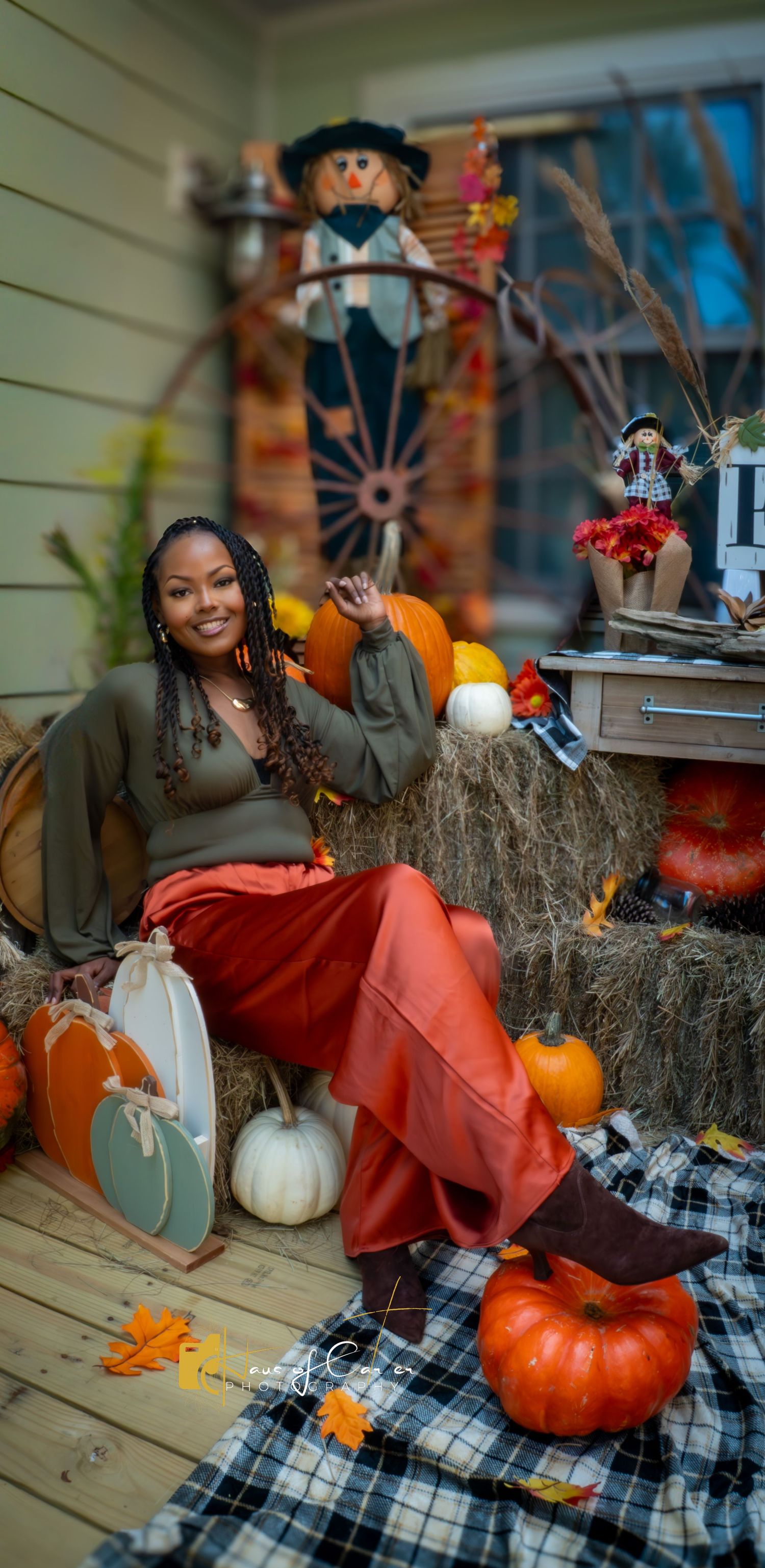 Fall themed photoshoot setup with pumpkins and rustic decorations on a porch.