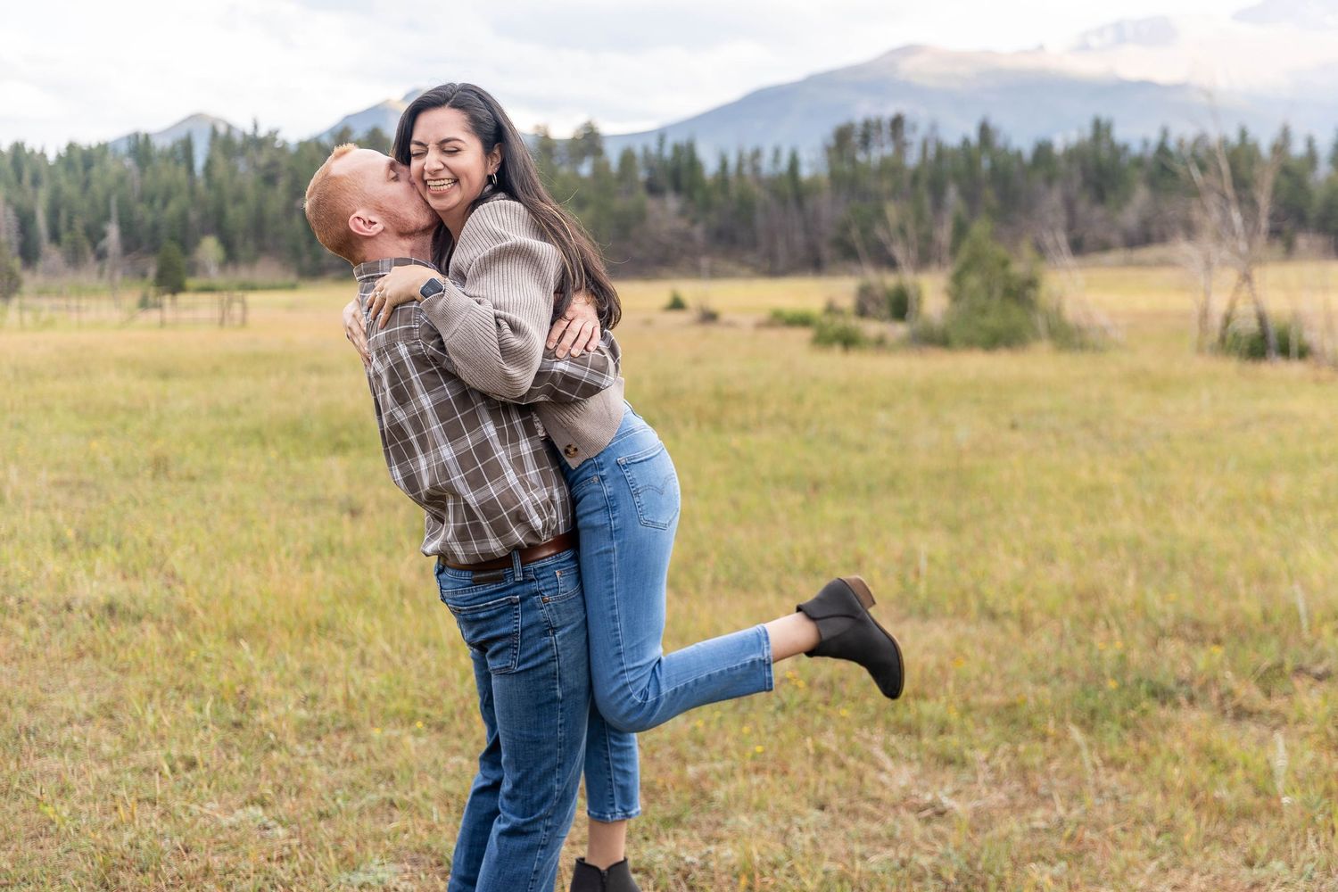 Golden autumn meadow with mountain backdrop sets scene for romantic outdoor moment.