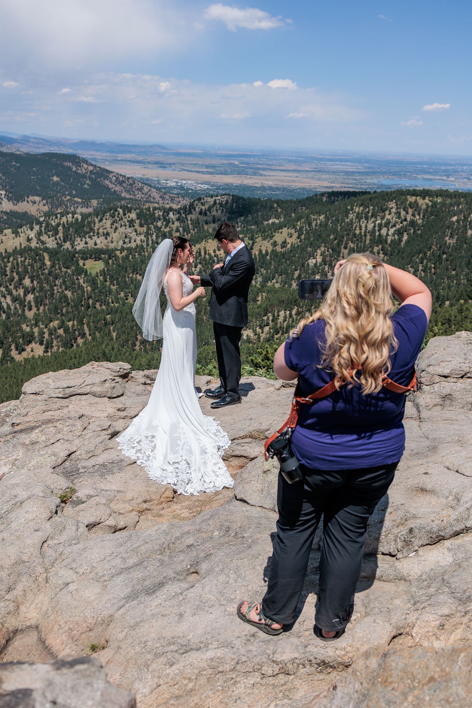 Wedding ceremony taking place on a scenic mountain overlook with dramatic landscape views.