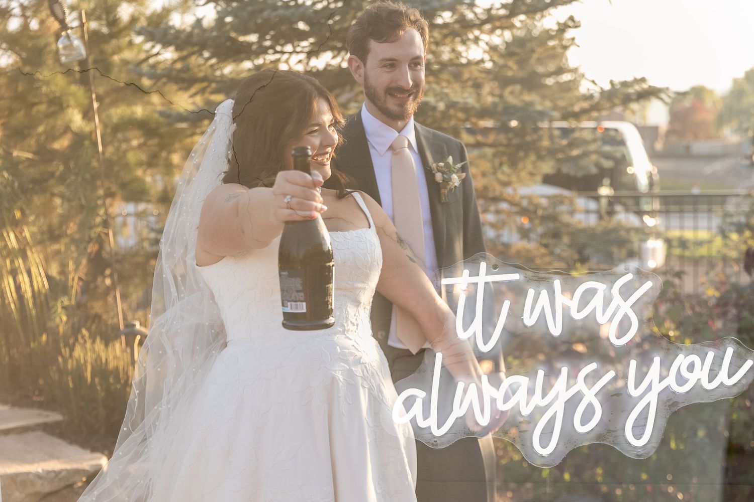 Romantic sunset wedding portraits with illuminated 'It was always you' neon sign.