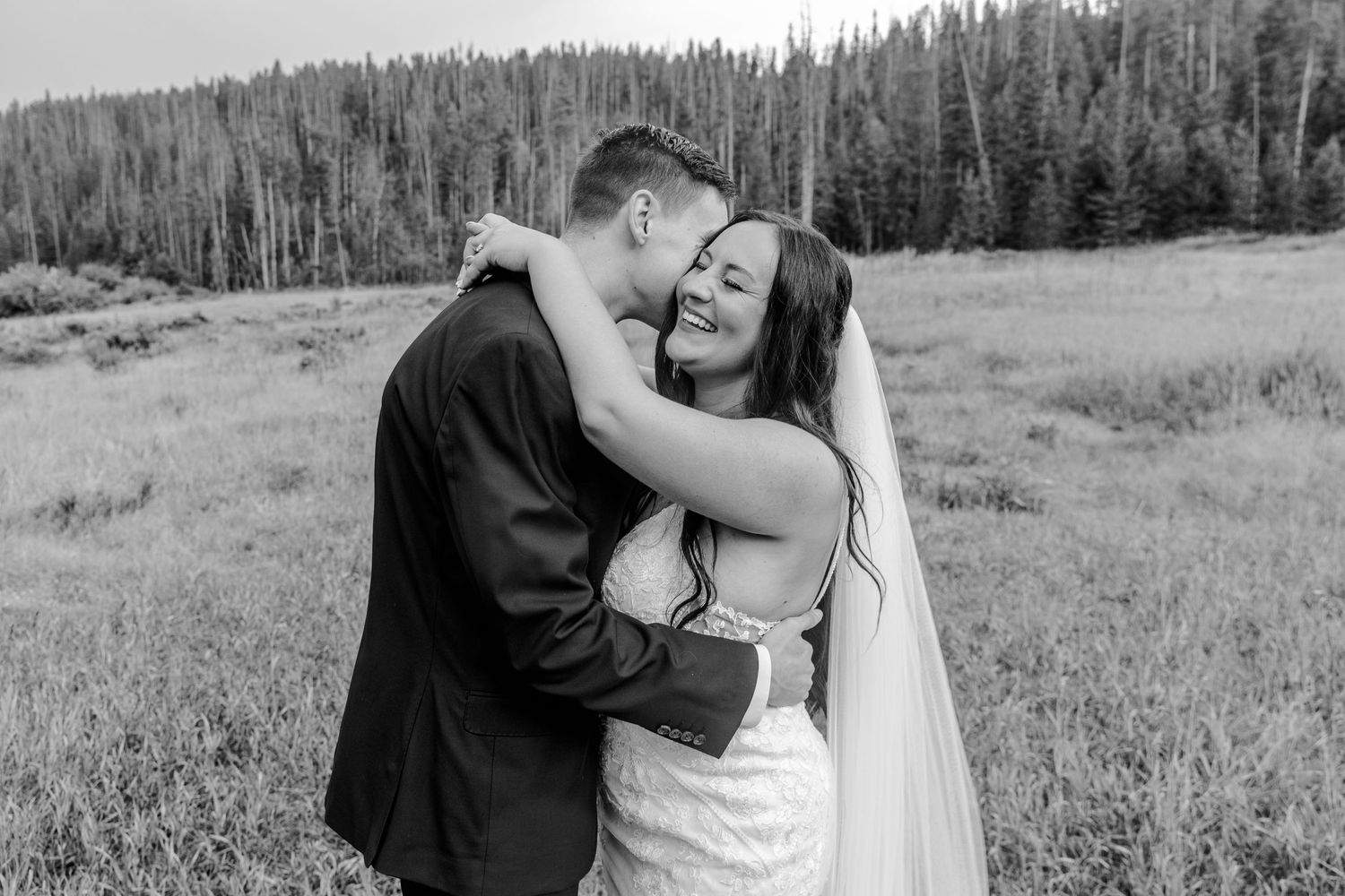 A black and white portrait of an intimate wedding moment in a mountain meadow.
